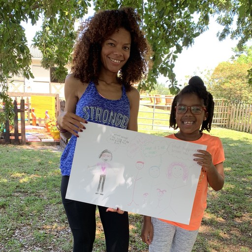 Kid and caregiver holding artword created during grief support therapy