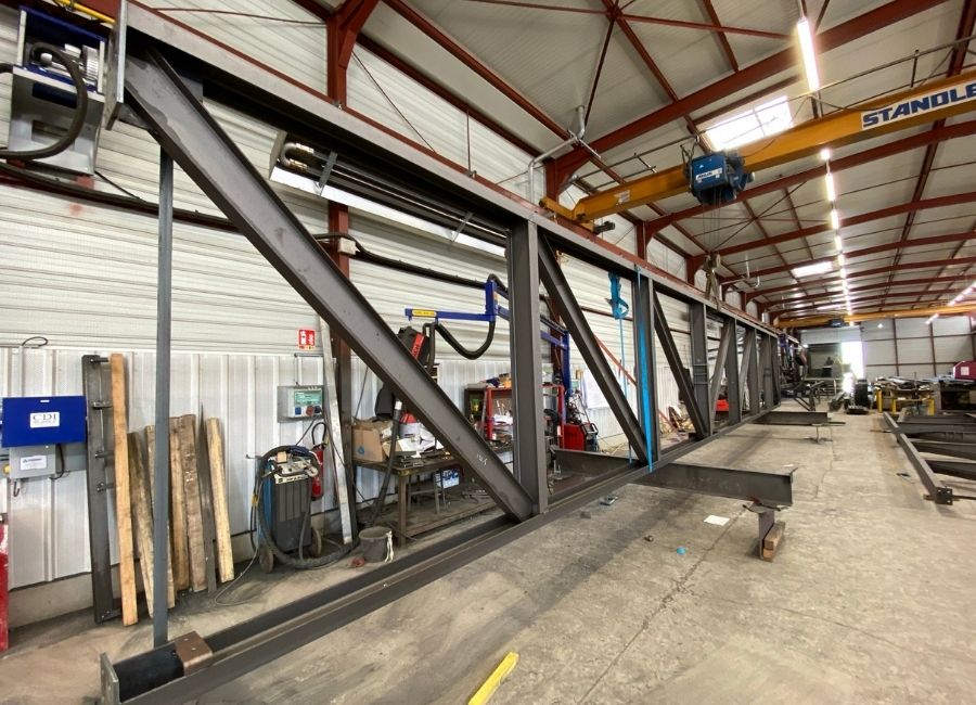 Vue intérieure d’un bâtiment en construction avec ossature bois et acier.