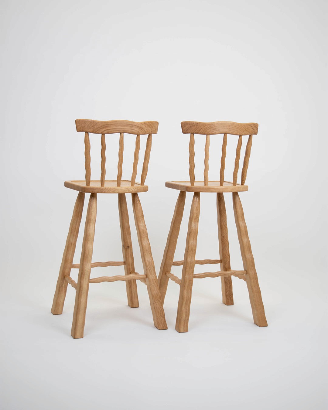 Two Oak bar stools on a white background