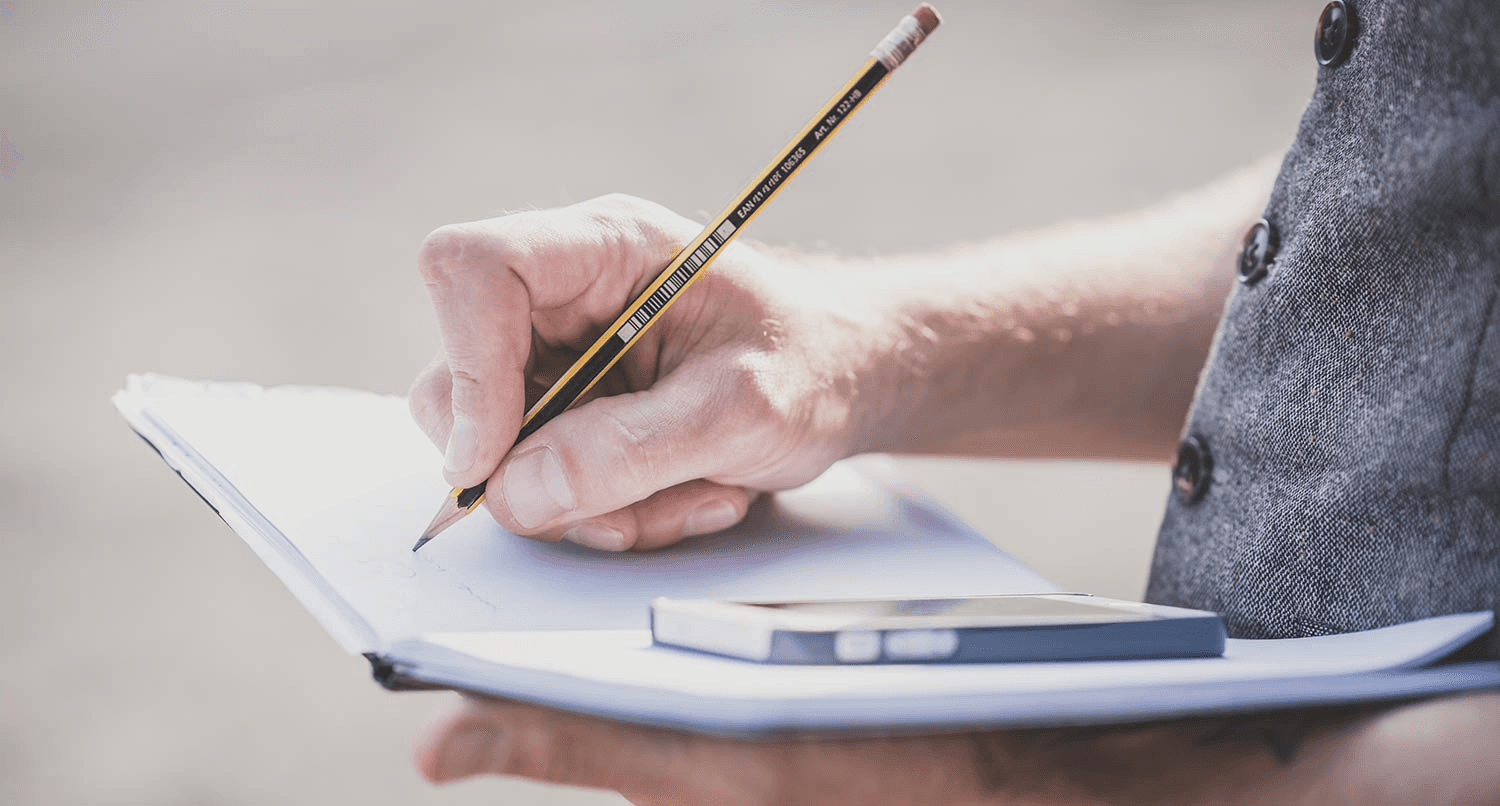 Person writing notes with a pencil -  What Is A Case Study In Research