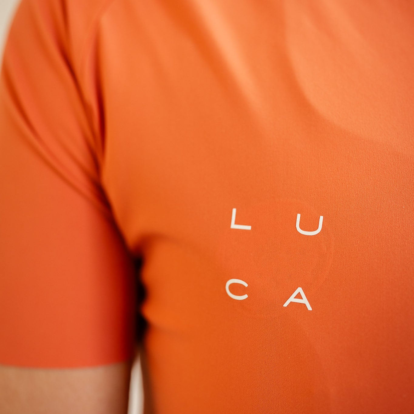LUCA logo detail on Soleil women's cycling jersey in aperol