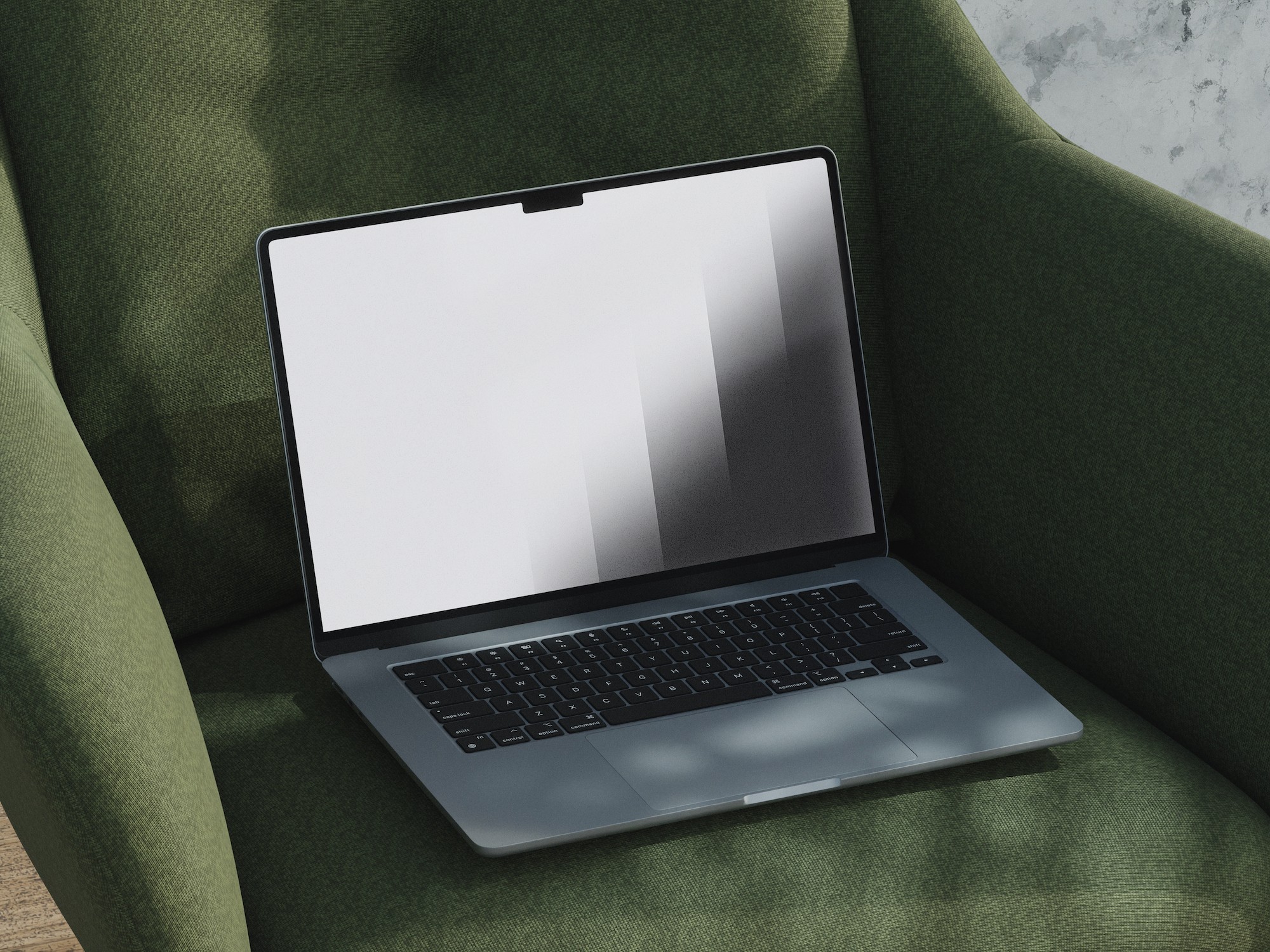 A sleek, modern laptop with a black keyboard and a screen displaying a minimalist grayscale gradient, resting on a plush, green armchair near a sunlit wall.