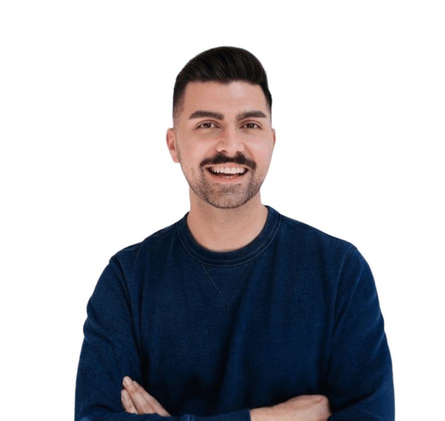 A man with a mustache wearing a blue sweater, smiling at the camera.