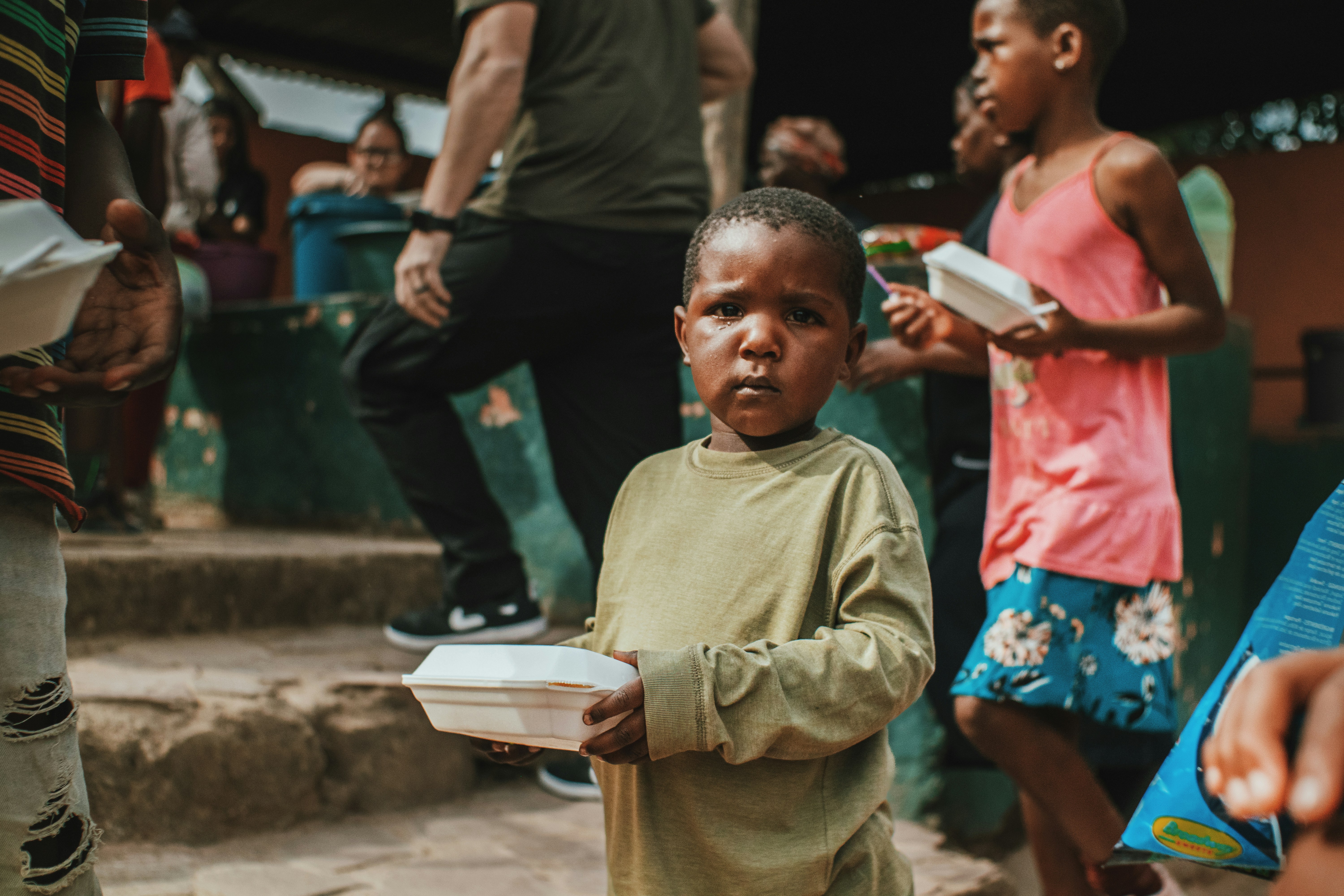 a young boy holding a box of food