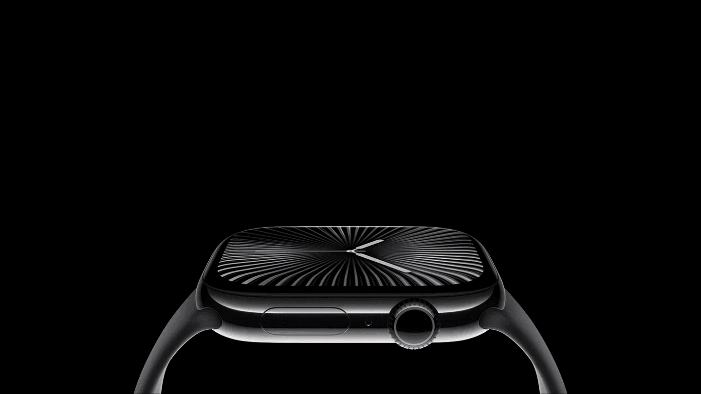 Man dressed in dark casual wear sitting alone in a stadium’s empty rows of purple chairs, lit by dramatic moody lighting.