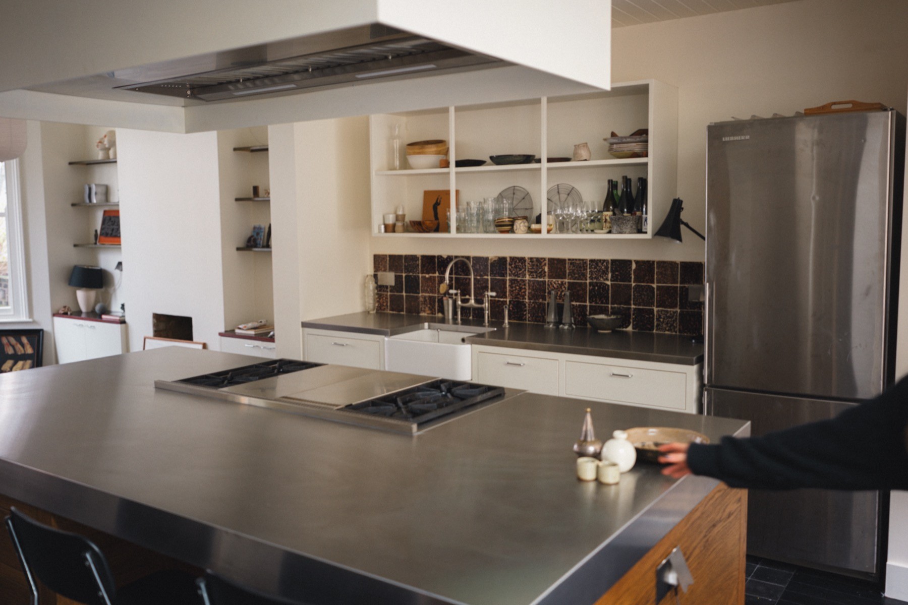 Contemporary kitchen with stainless steel worktop and timber island detail