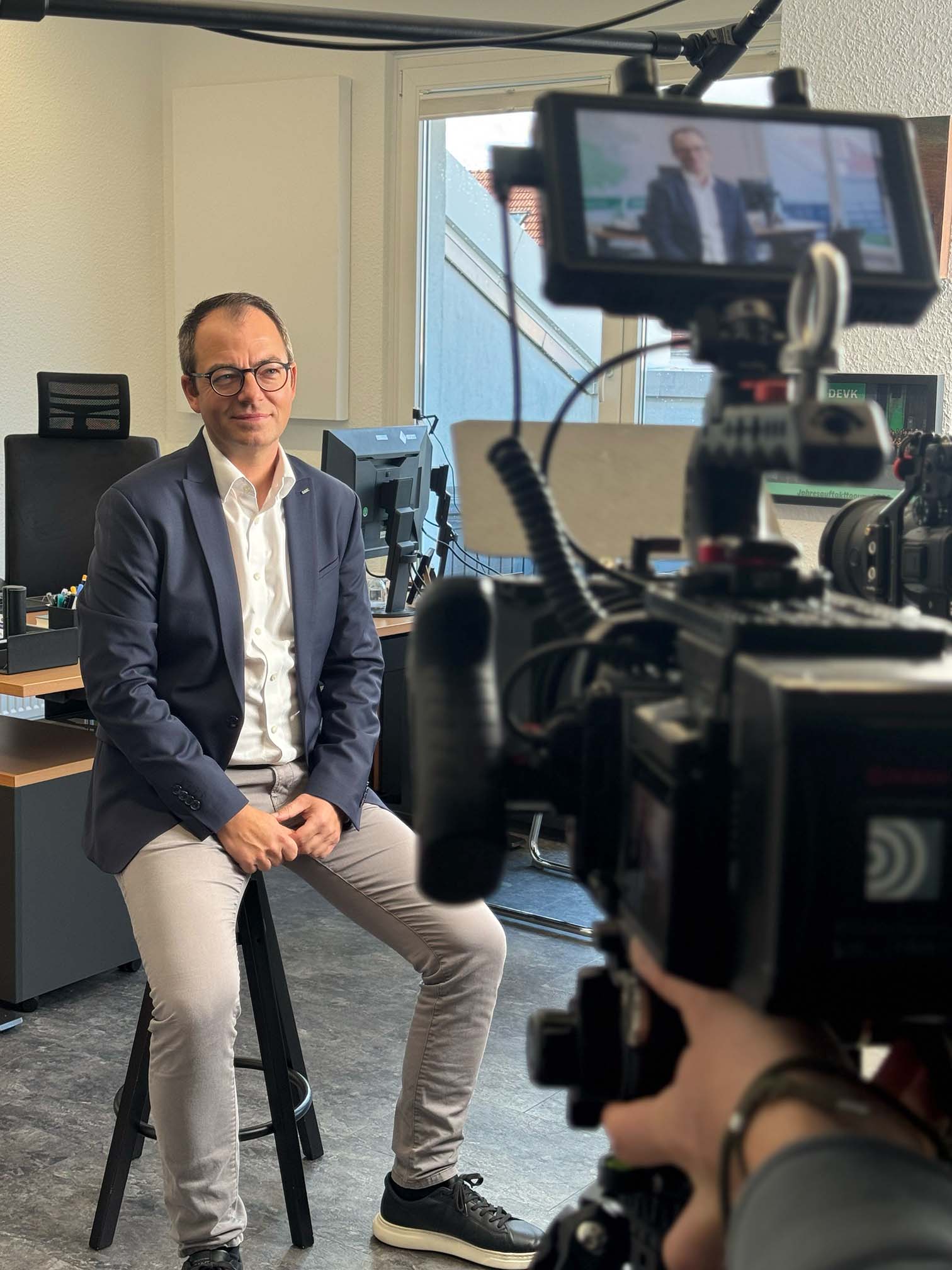 Man in office setting filmed for advertising campaign, highlighting strategic film production and storytelling in social media.