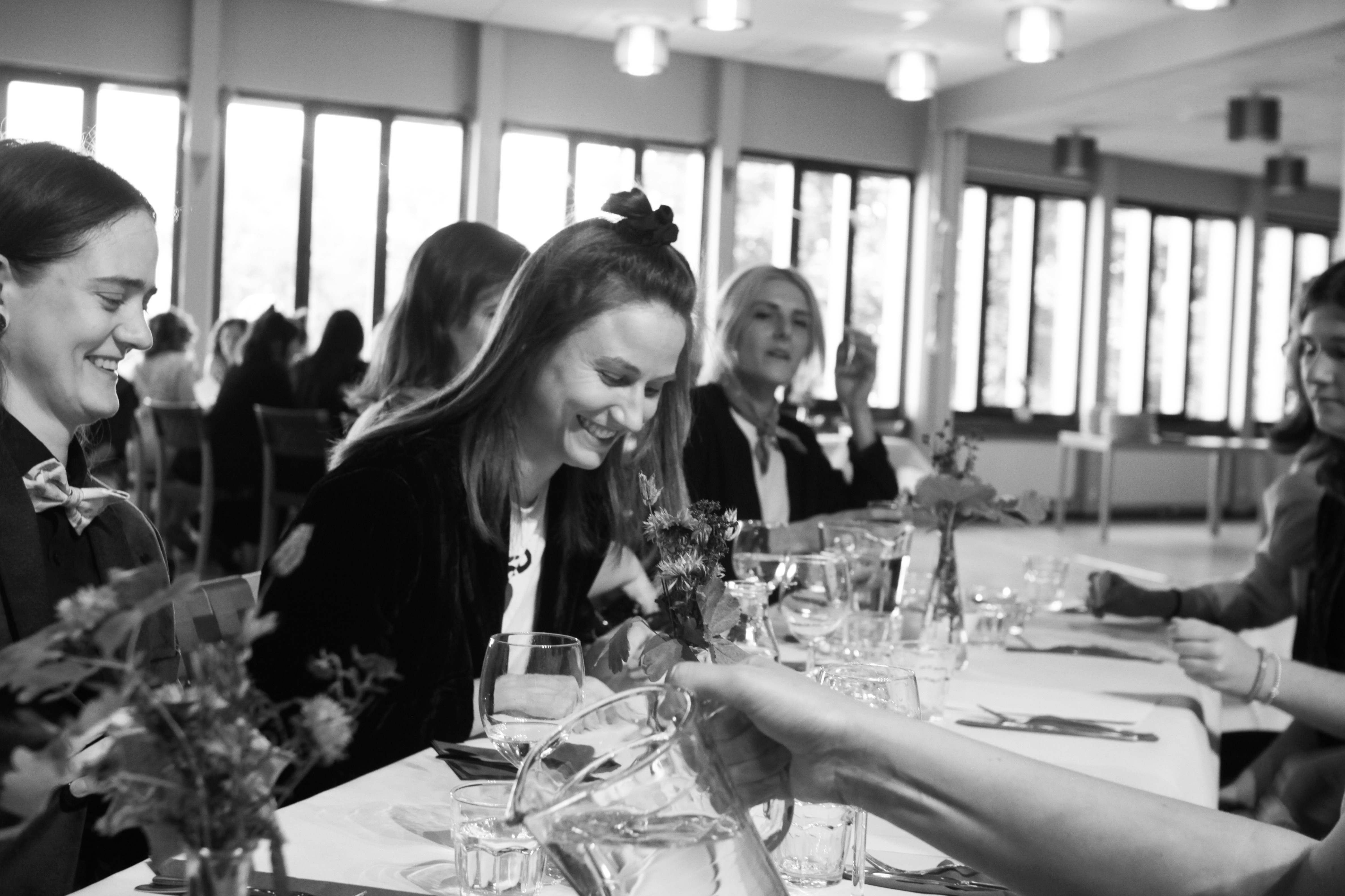A group of people smiling at a dining table.