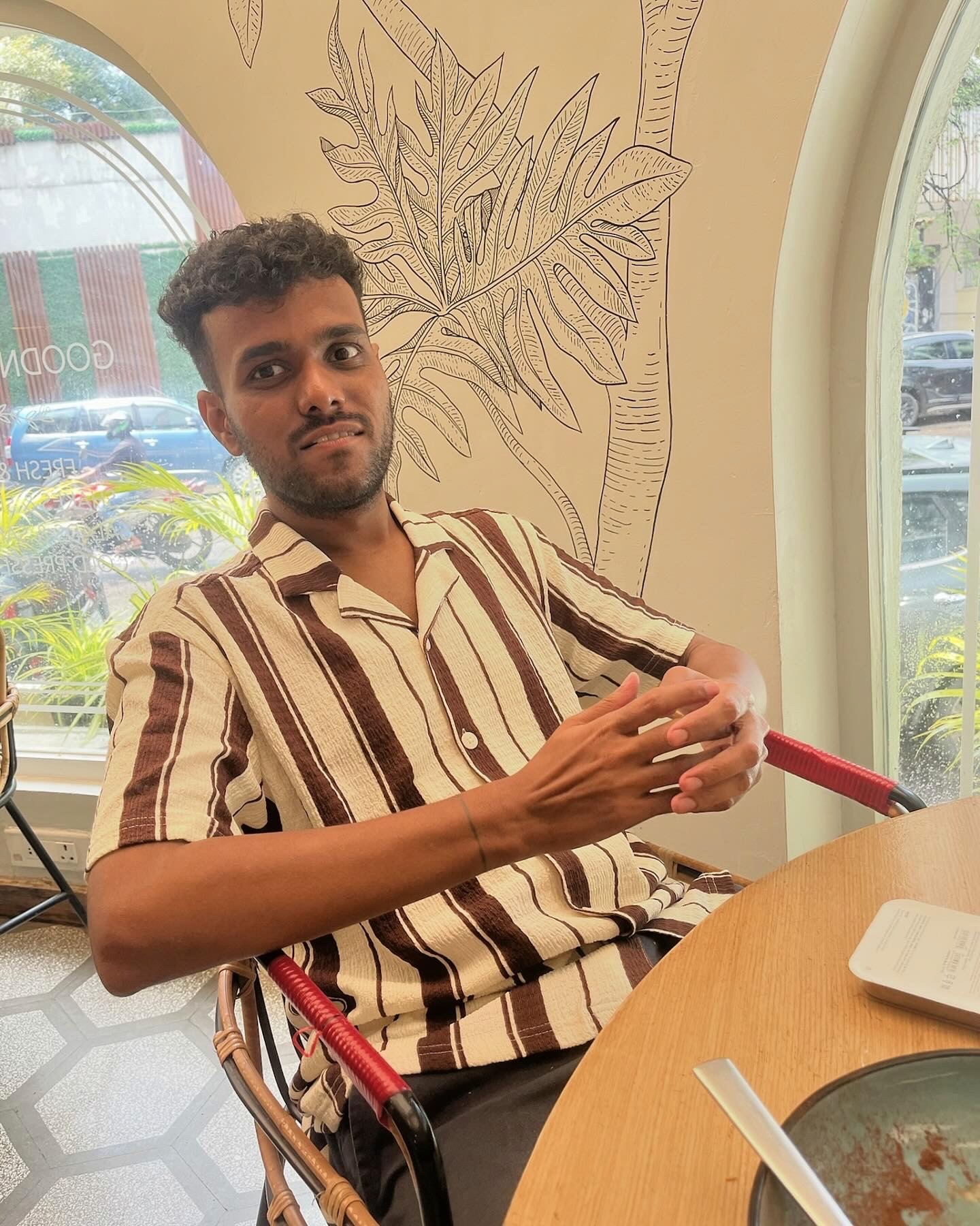 Anthony Stephen Mendes comfortably sitting in a beige shirt with brown stripes at Smoke House Deli, Pali Hill, Bandra