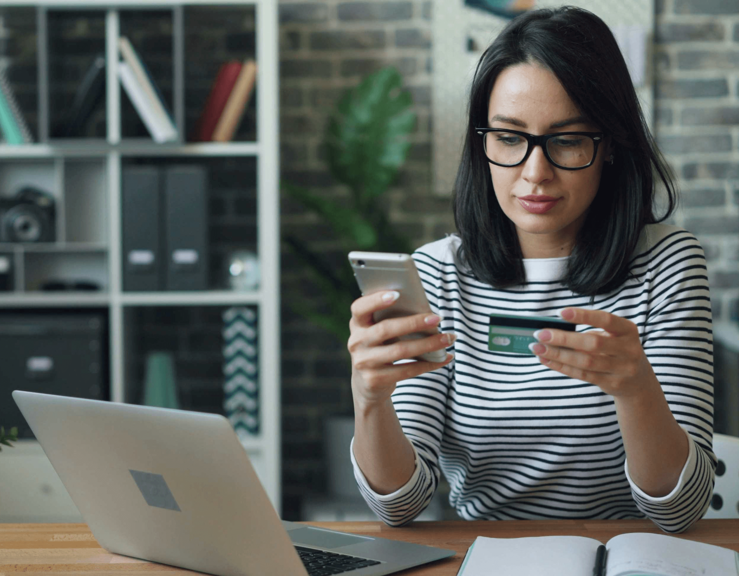 a woman looking at their phone and credit card