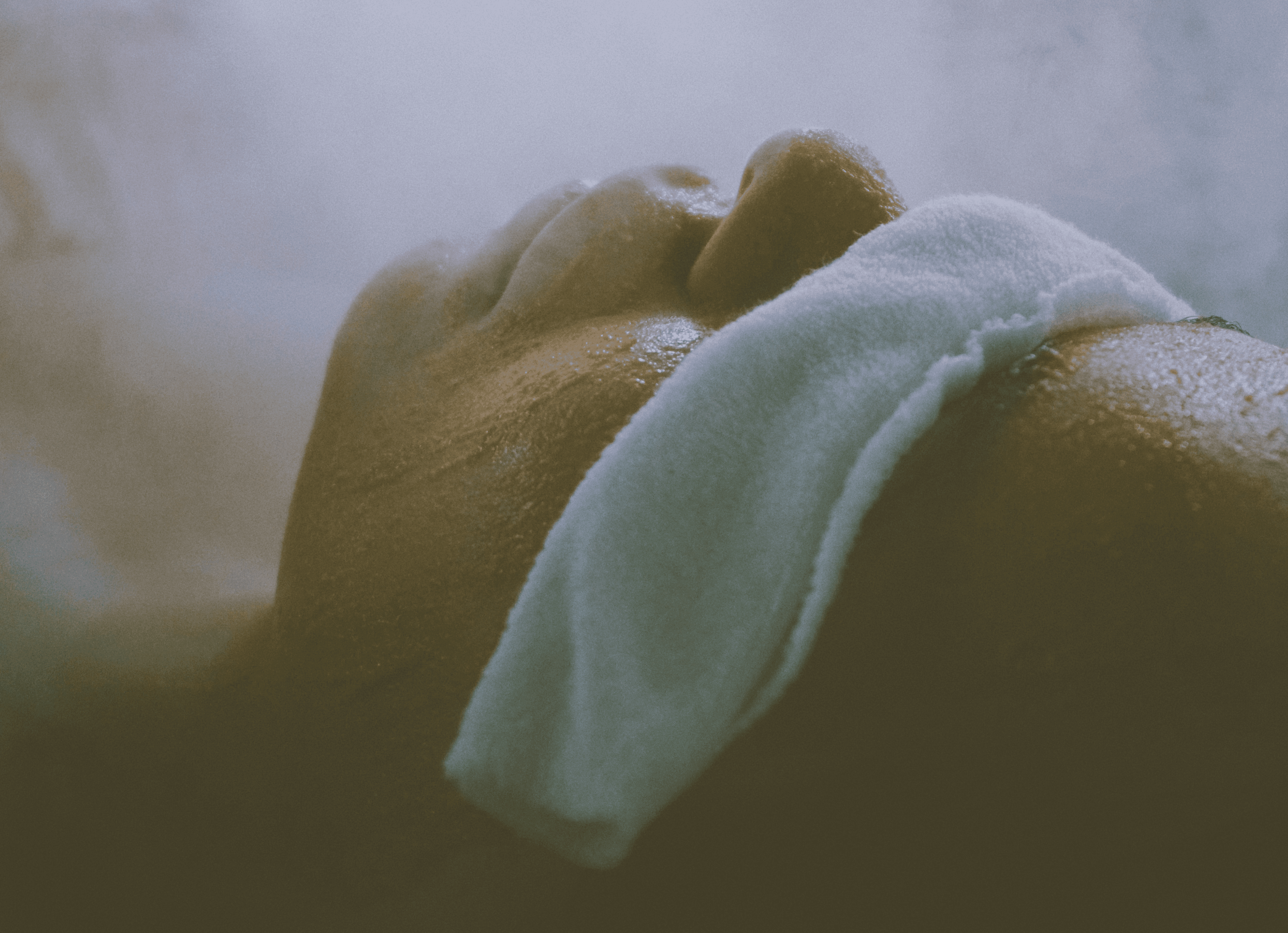 a woman laying down in a bathtub with steam coming out of it