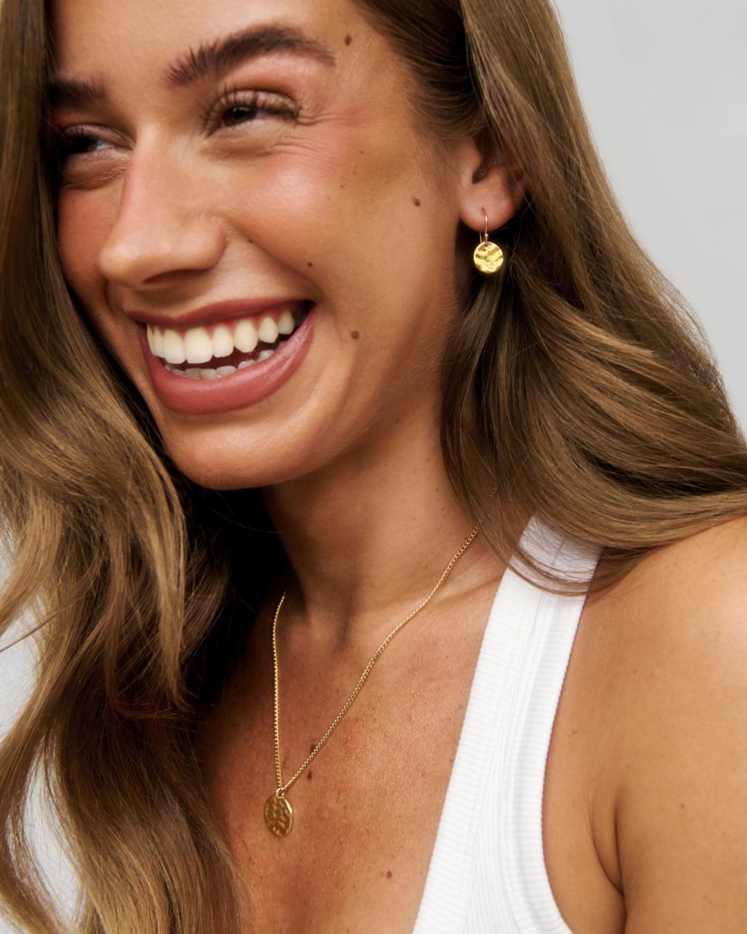 gold pendant being worn