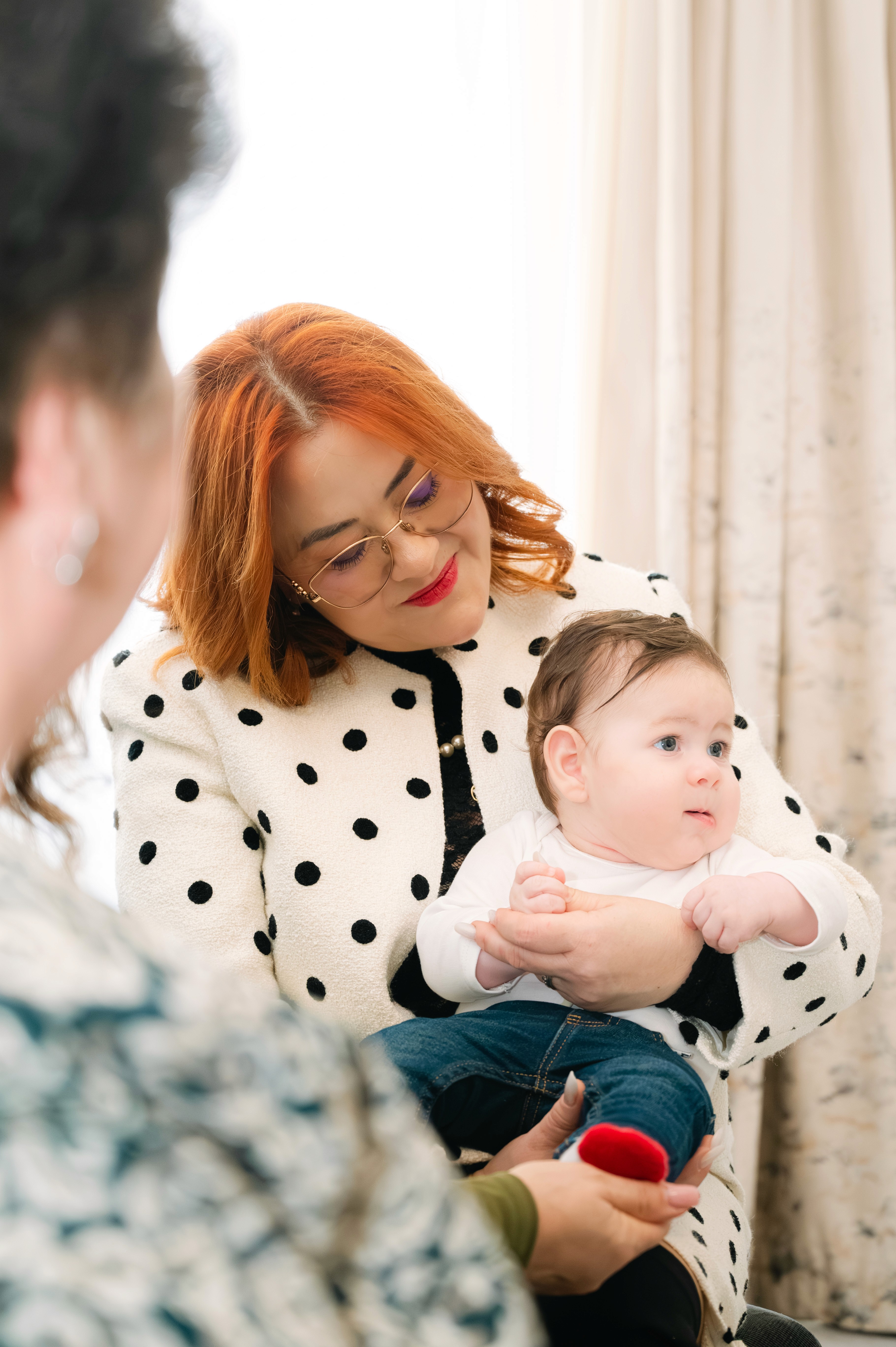 Bunica ținând bebelușul în brațe, cadru cald și expresiv.