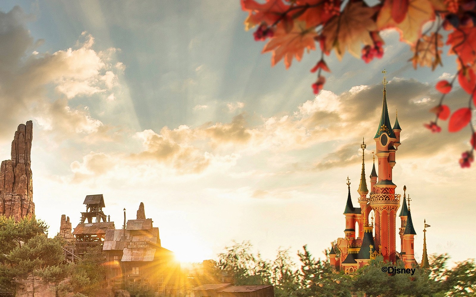 Disneyland Paris-slottet og Big Thunder Mountain ved solnedgang.