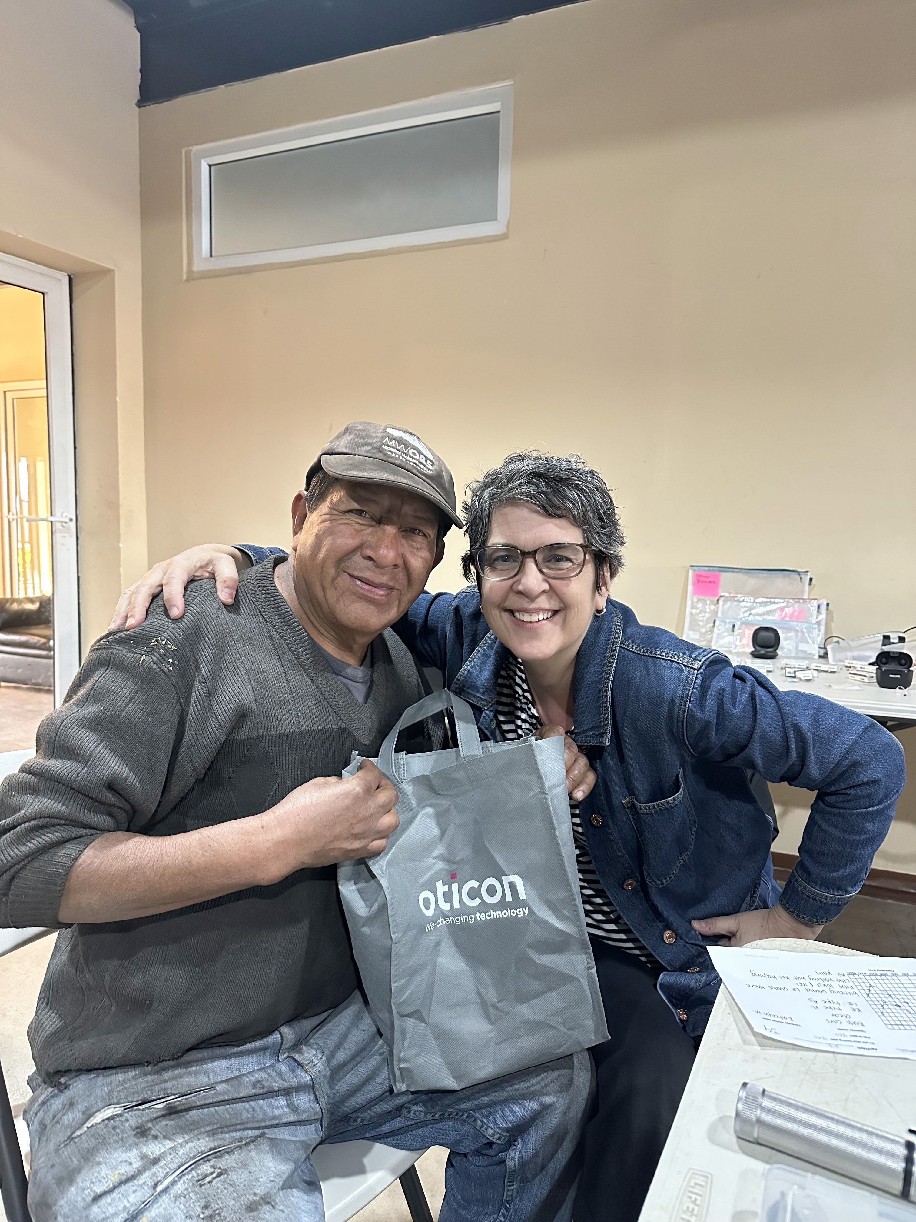 Woman holds a camera, seemingly thoughtful.