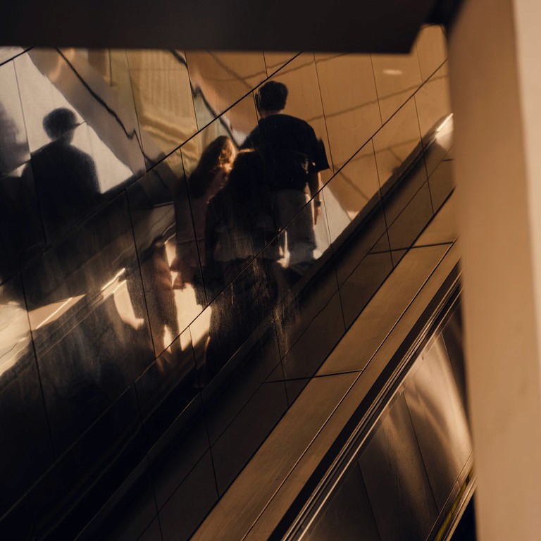 Two people riding the Escalator at a subway station in Vienna