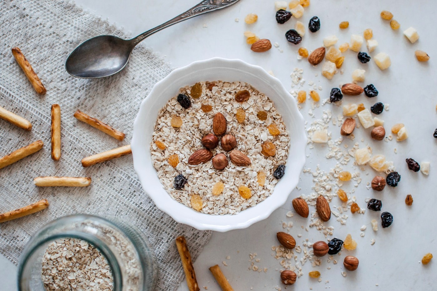 A bowl of oats topped with nuts and dried fruit, a whole grain rich in fiber that supports regularity