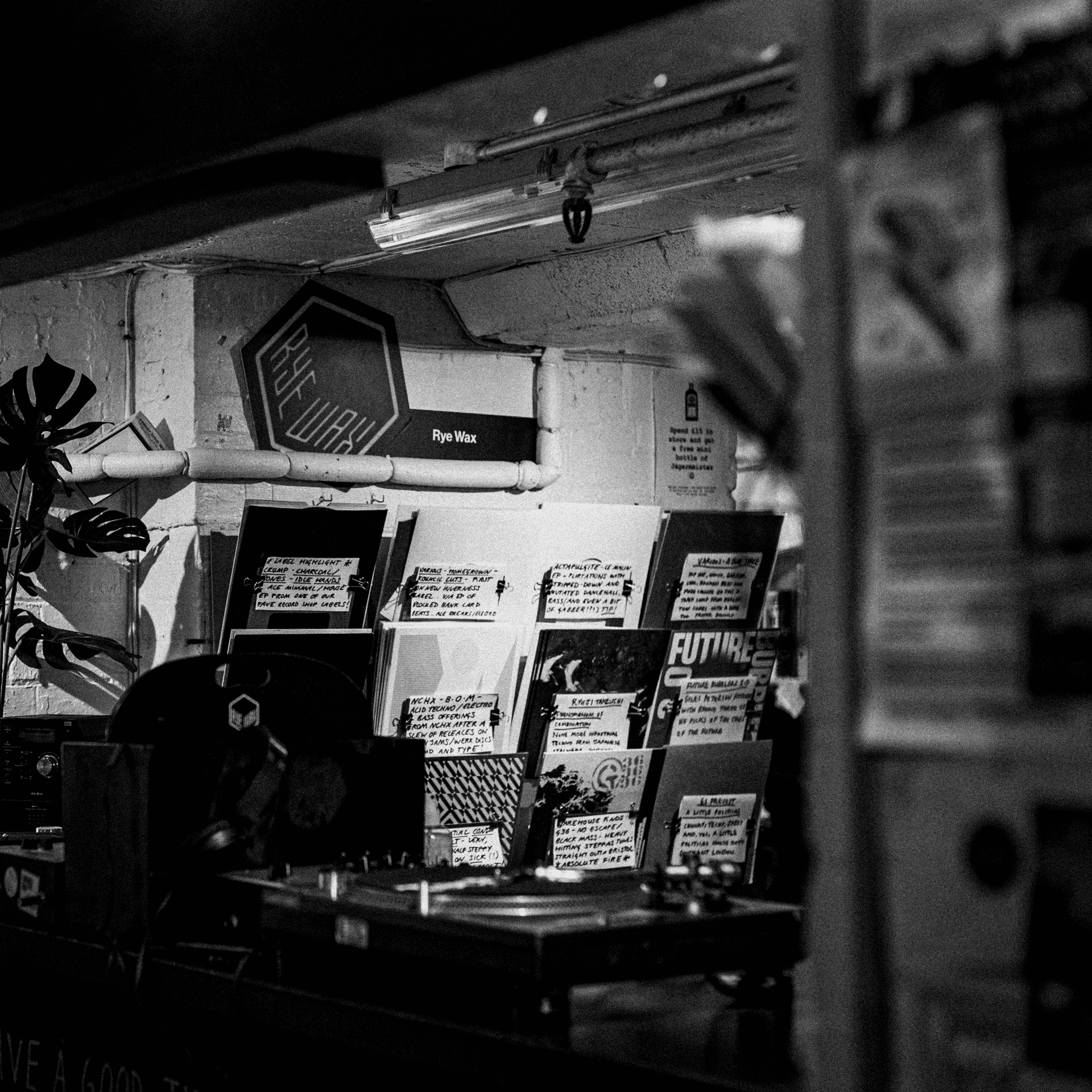 Contextual shot of Rye Wax record shop in Peckham there are vinyl records with hand written labels hanging on the back wall