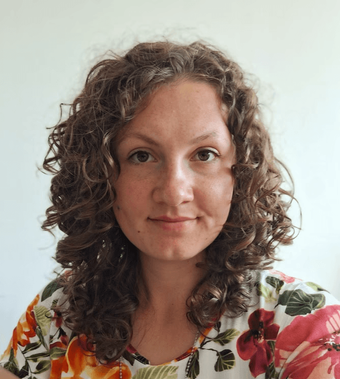 headshot of Alexandra, brown curly hair and brown eyes