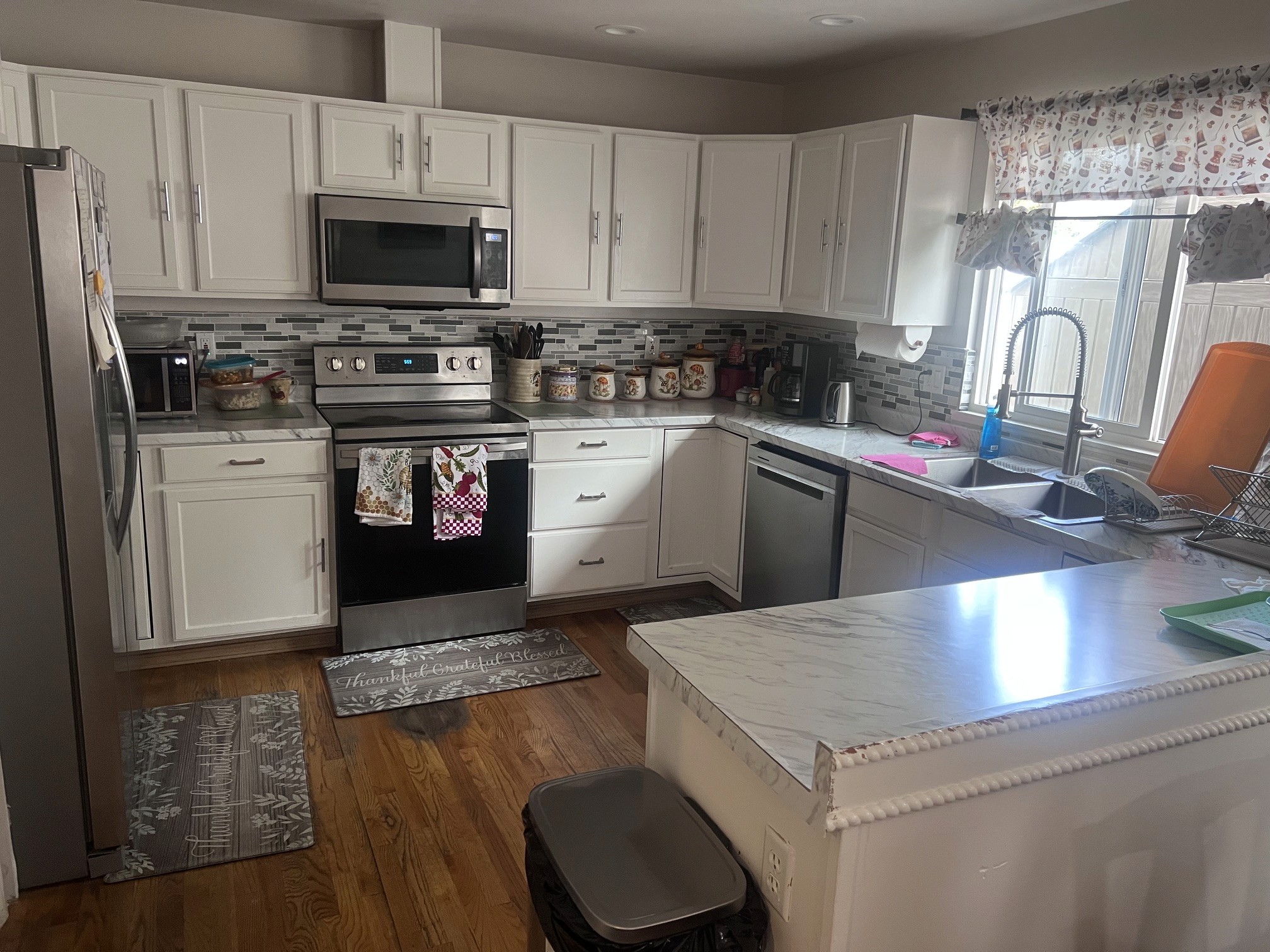The Abba Care kitchen: white cabinets, marble countertops, and a bright window above the sink