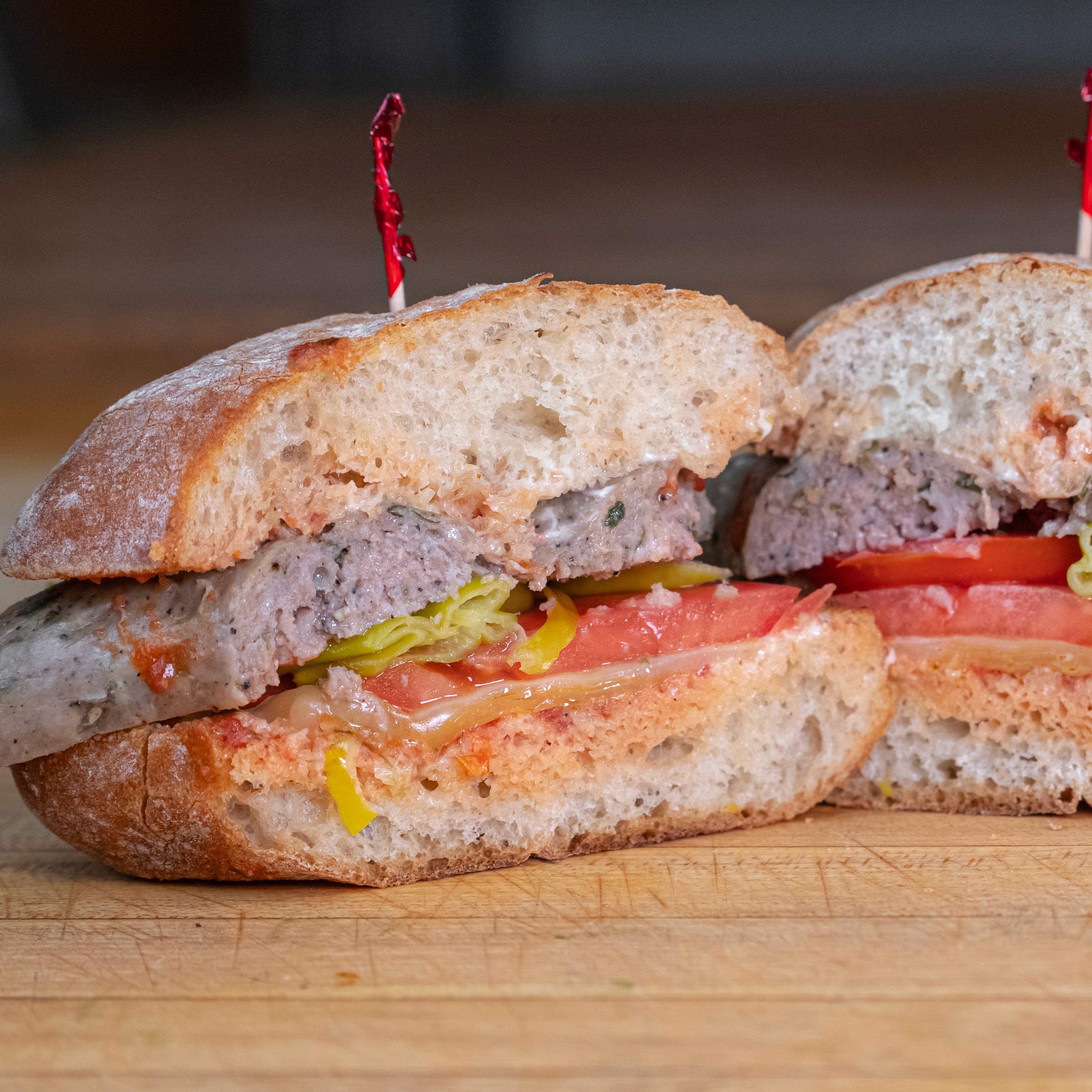 Hand-rolled meatball sandwich with pepperoncini and tomato on fresh ciabatta