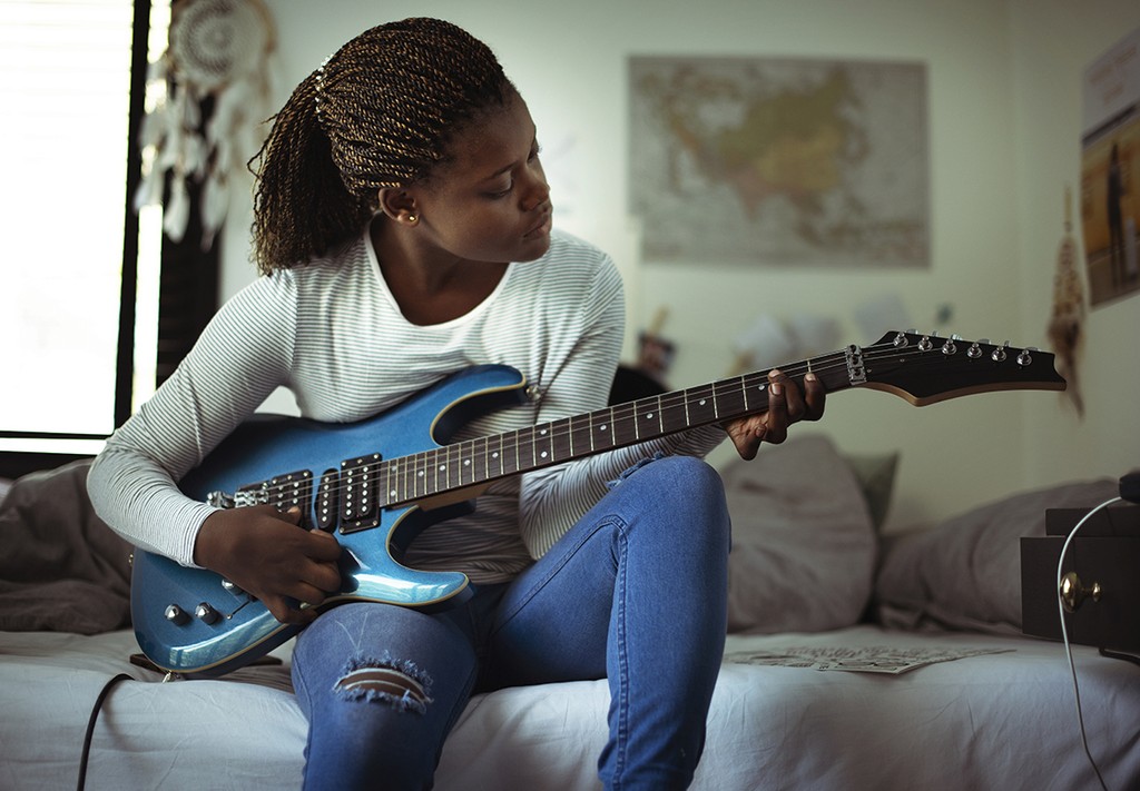 child on couch playing guitar