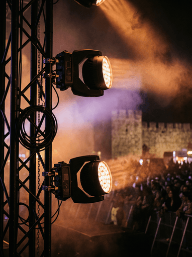 Young woman with short, dark hair and a yellow sweater looks serious, surrounded by hands holding smartphones, conveying intrusion and tension.