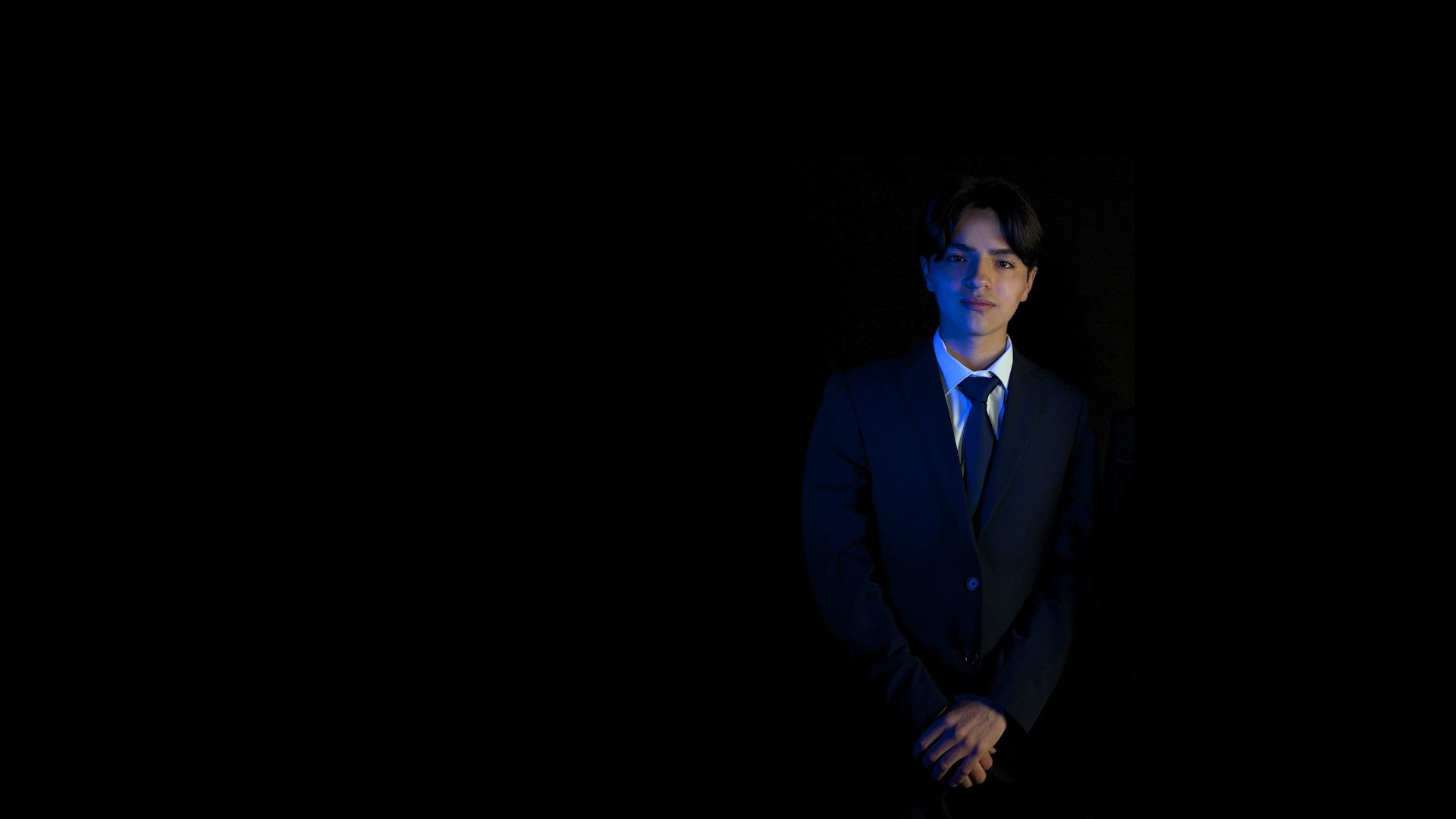 A fast black sports car races down the highway.