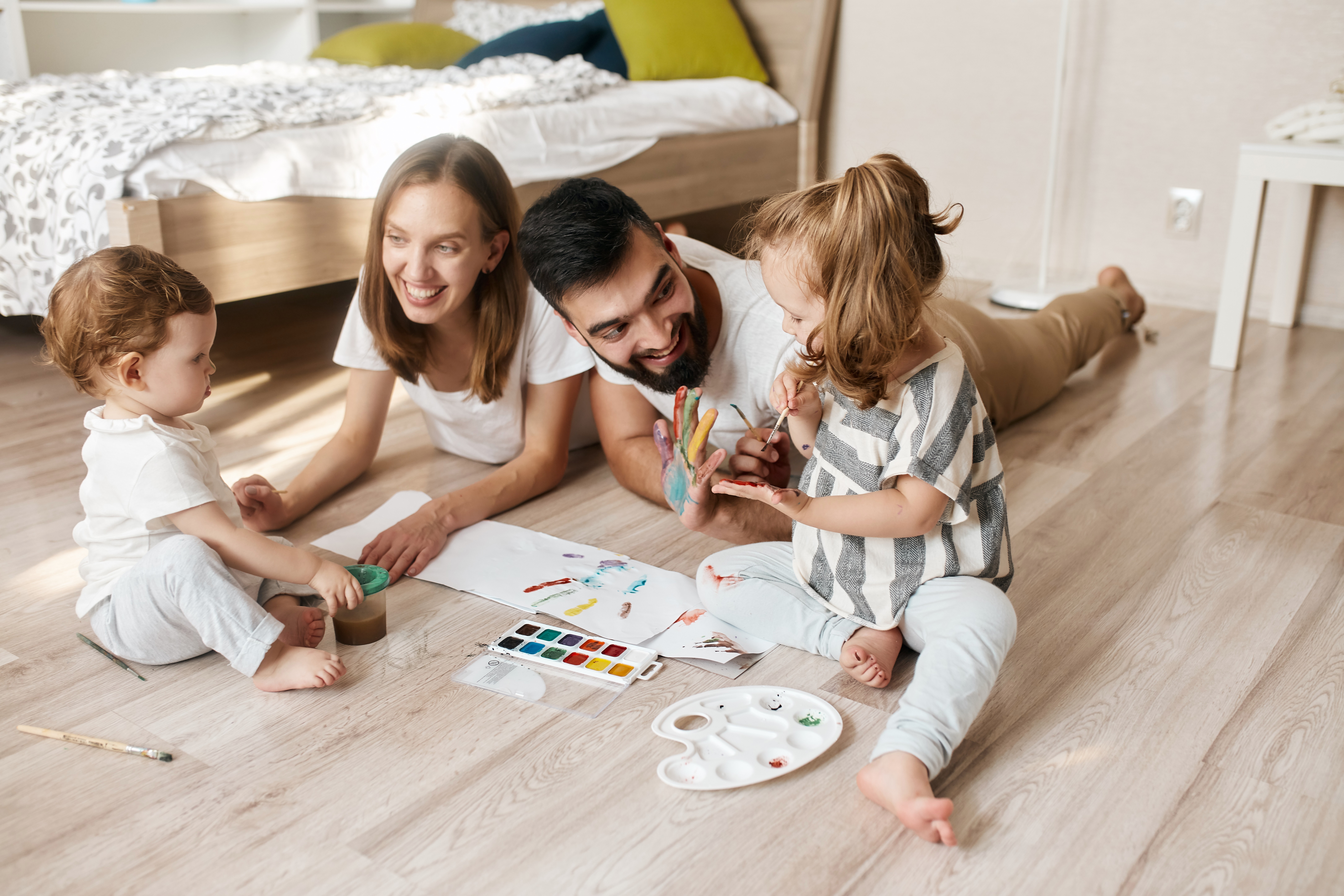 A family enjoys creative play on LUXO’s light wood-look hybrid flooring, highlighting a stain-resistant, safe, and family-friendly surface designed for everyday Australian living.
