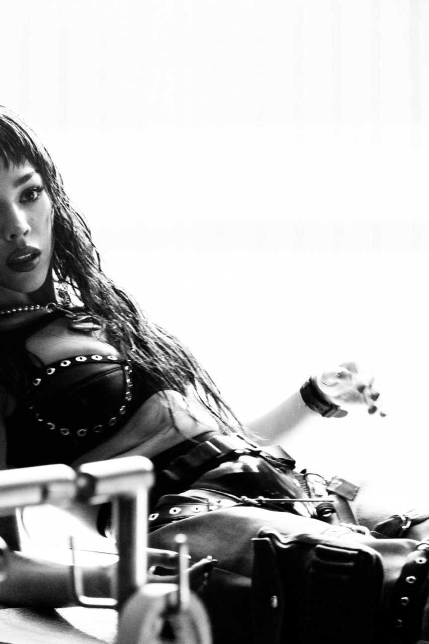 Behind the scenes, black and white picture of Danna on set, sitting on a chair, 