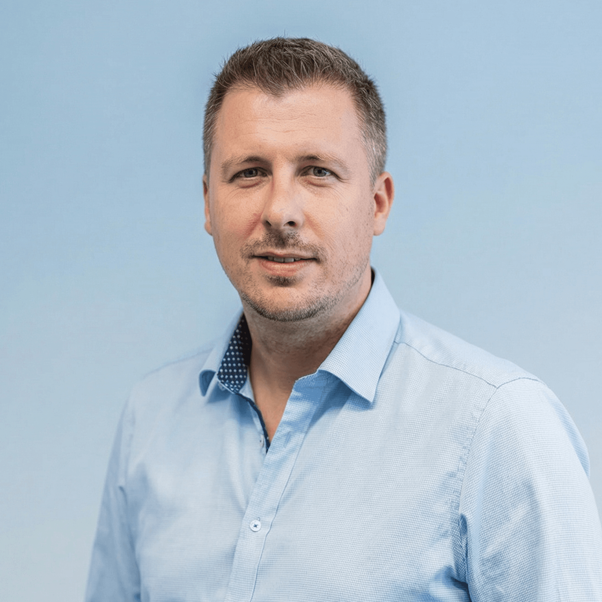 Portrait of a laughing person with curly hair wearing a white shirt