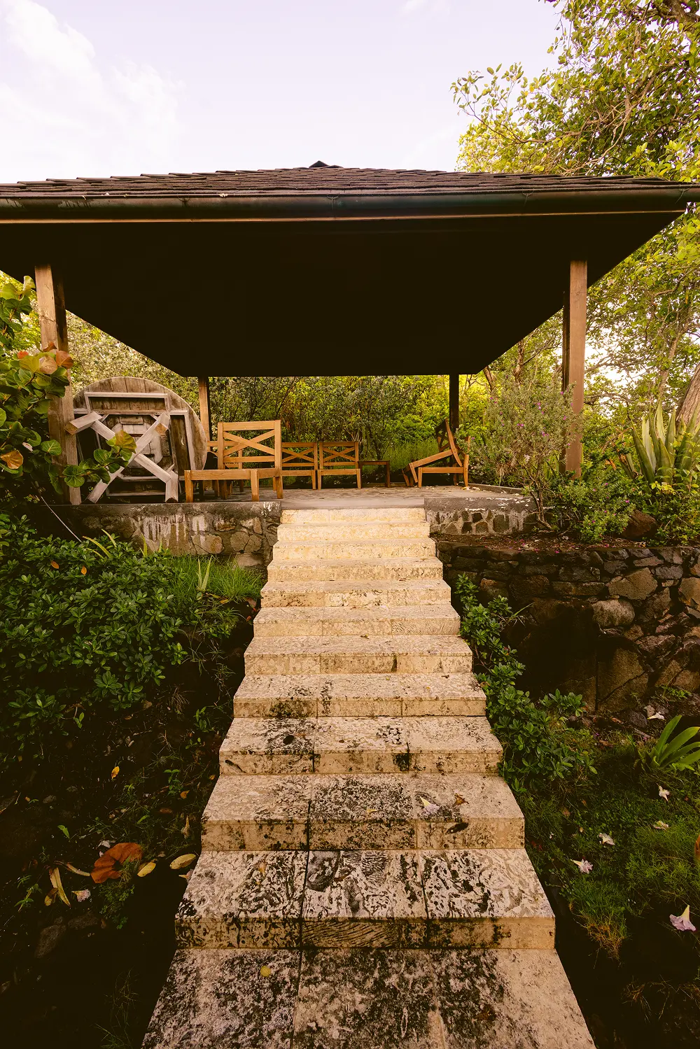 Open-air pavilion lounge with wooden ceiling, natural light, and relaxed seating