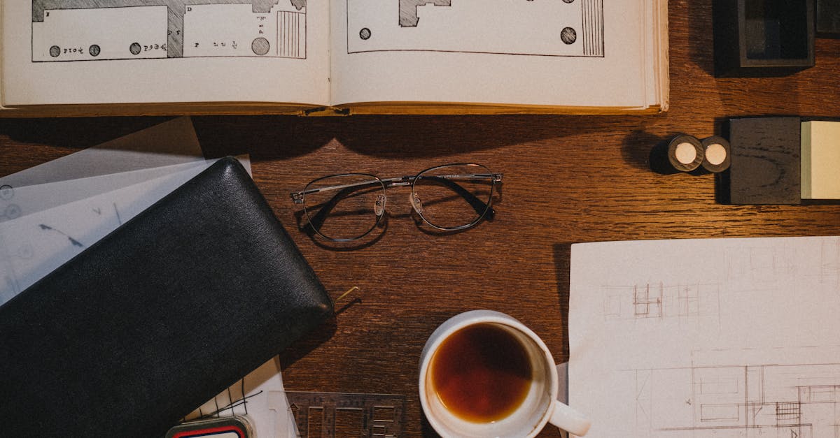 Flat lay of an architect's workspace with sketches, coffee, and drawing tools on a wooden desk.