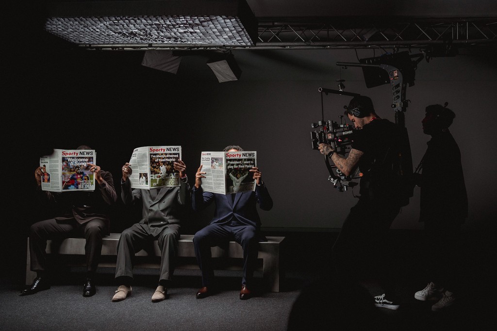 Steadicam shot of three actors reading newspapers on the For Everybody set
