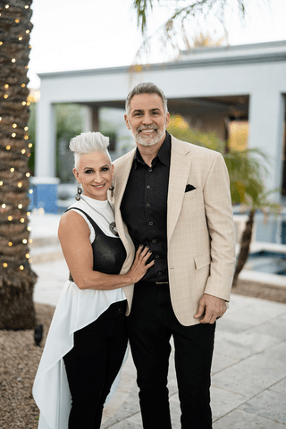 A vibrant bridal bouquet featuring a mix of red, pink, and purple flowers.