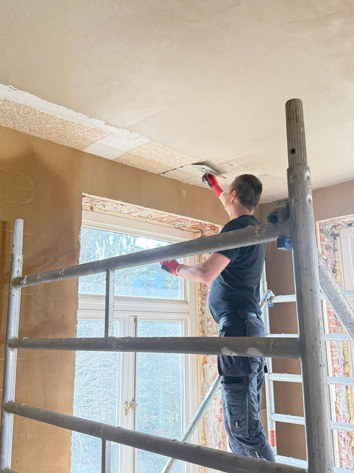 Plasterer finishing a ceiling lined with RespiraDrywall hemp board