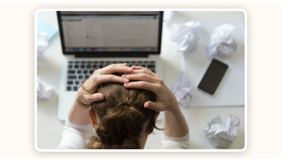 Person stressed at desk with laptop, symbolizing frustration and work overwhelm