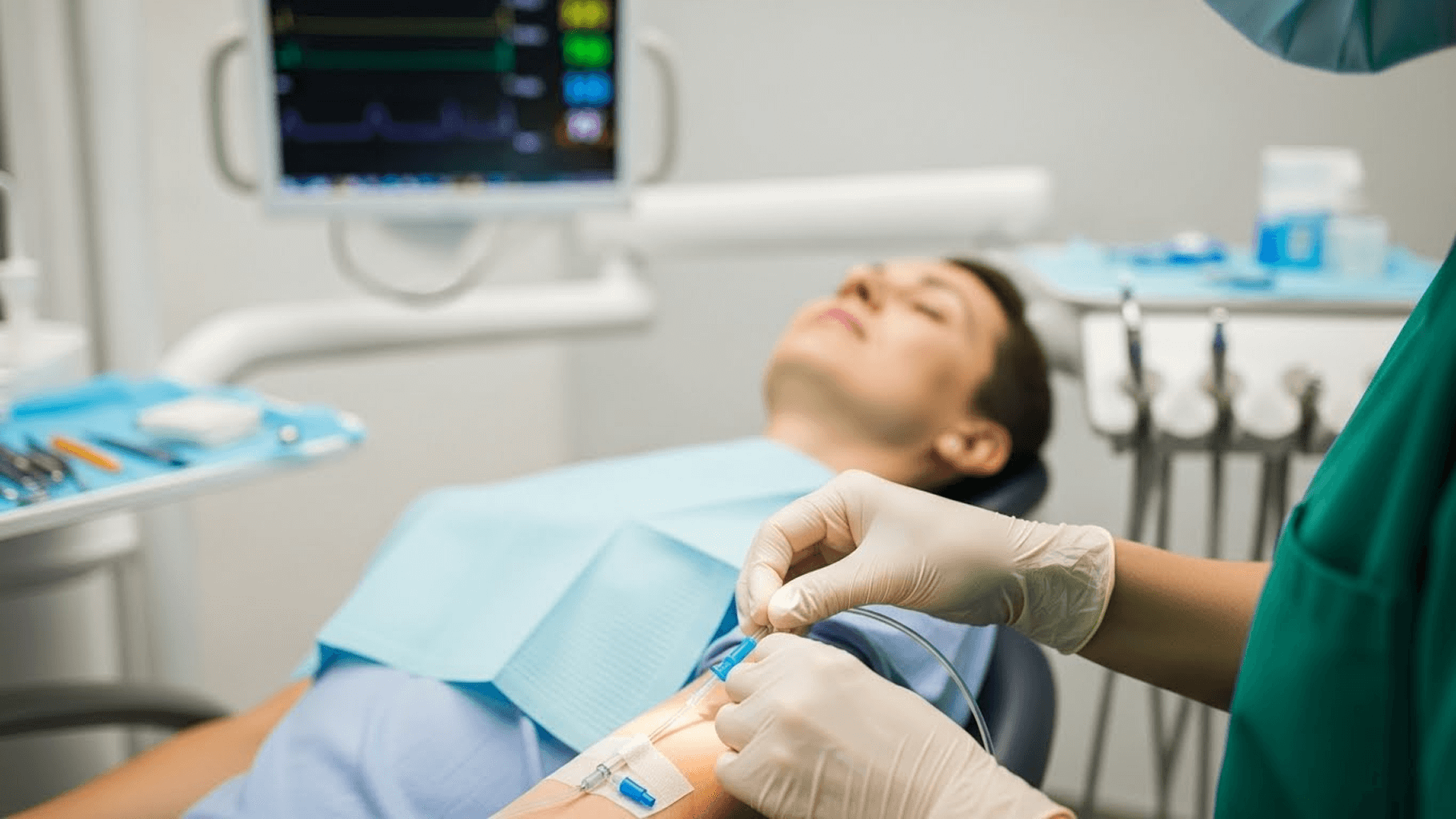 Dentist administering IV moderate sedation to patient in dental office