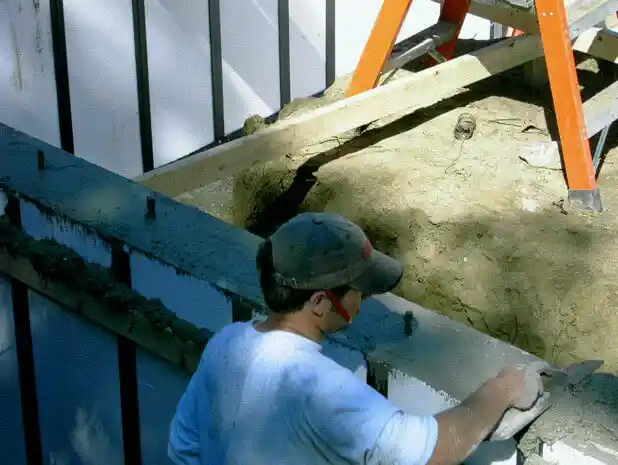 A man smoothing concrete poured into an ICF wall