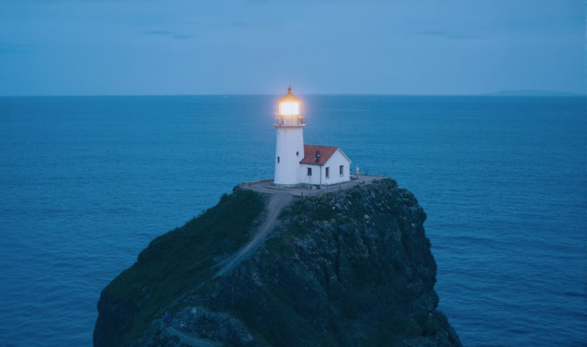 A lighthouse on an island with the blue sea in the background