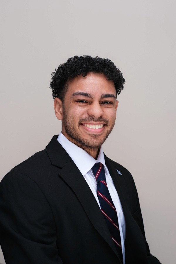Alternate corporate headshot of a smiling man in a suit
