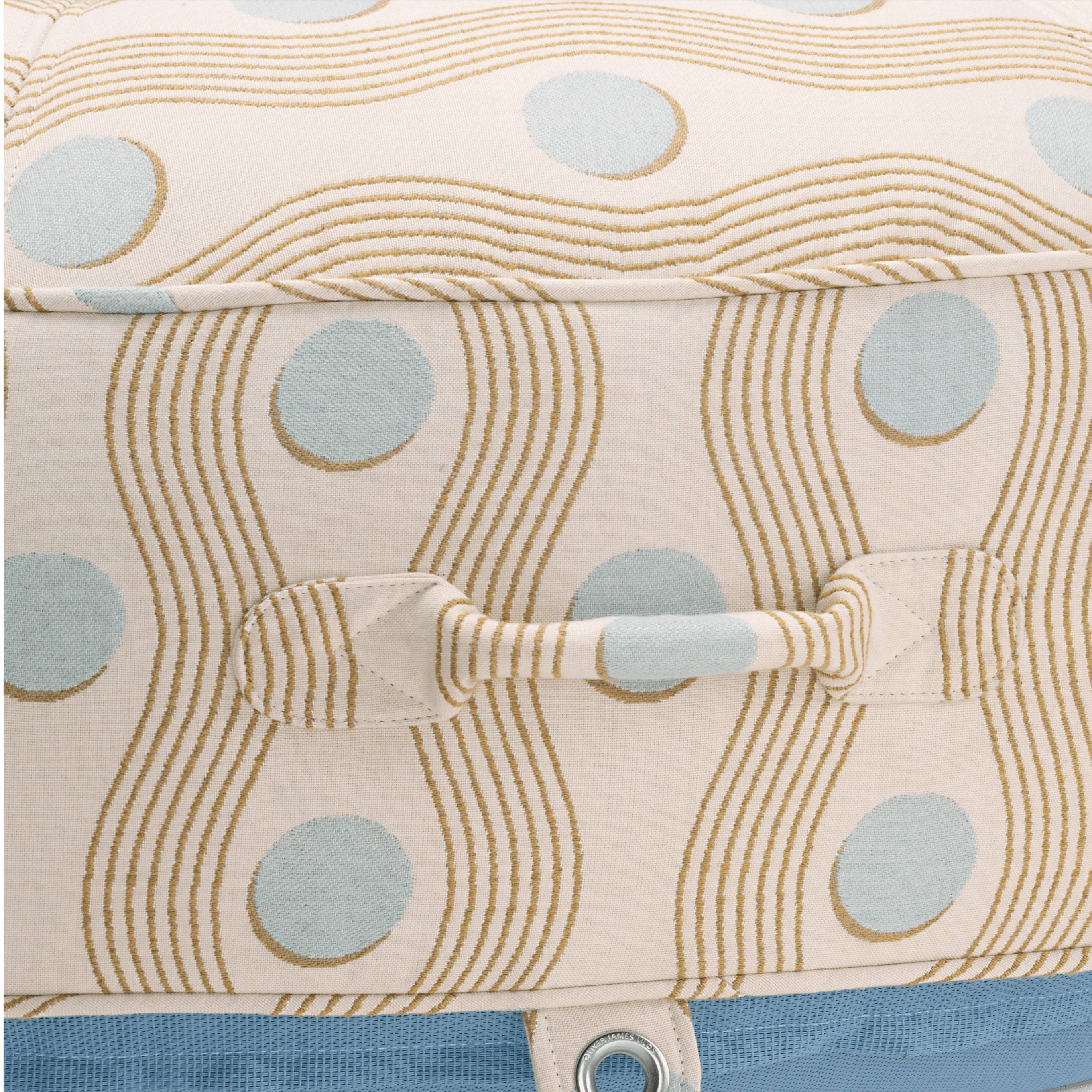 Close-up of pool float showing cream geometric-weave handle, block-print-inspired pattern, and stainless eyelet