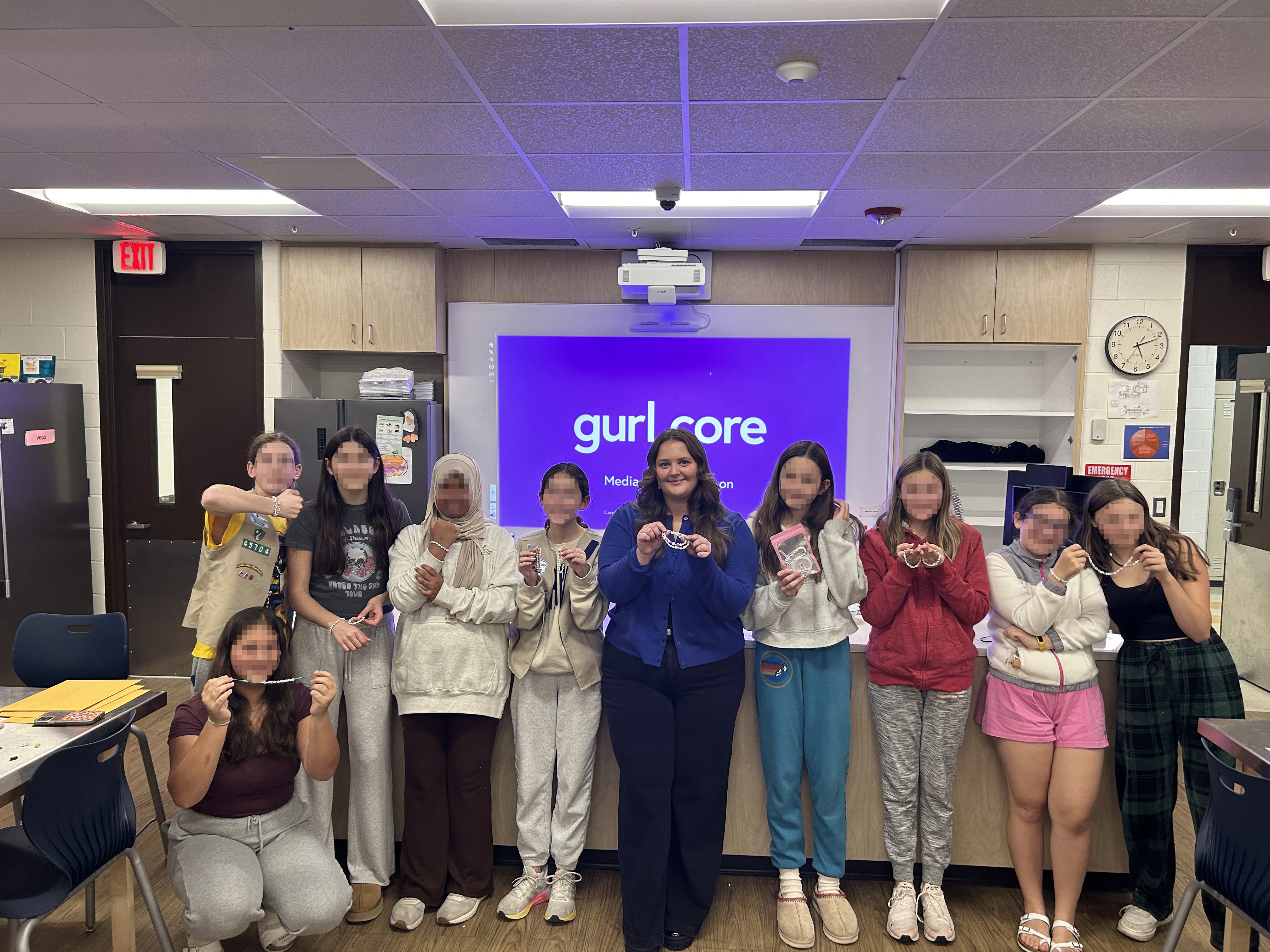 Caroline Schwarm with a Girl Scout Troop holding up friendship bracelets