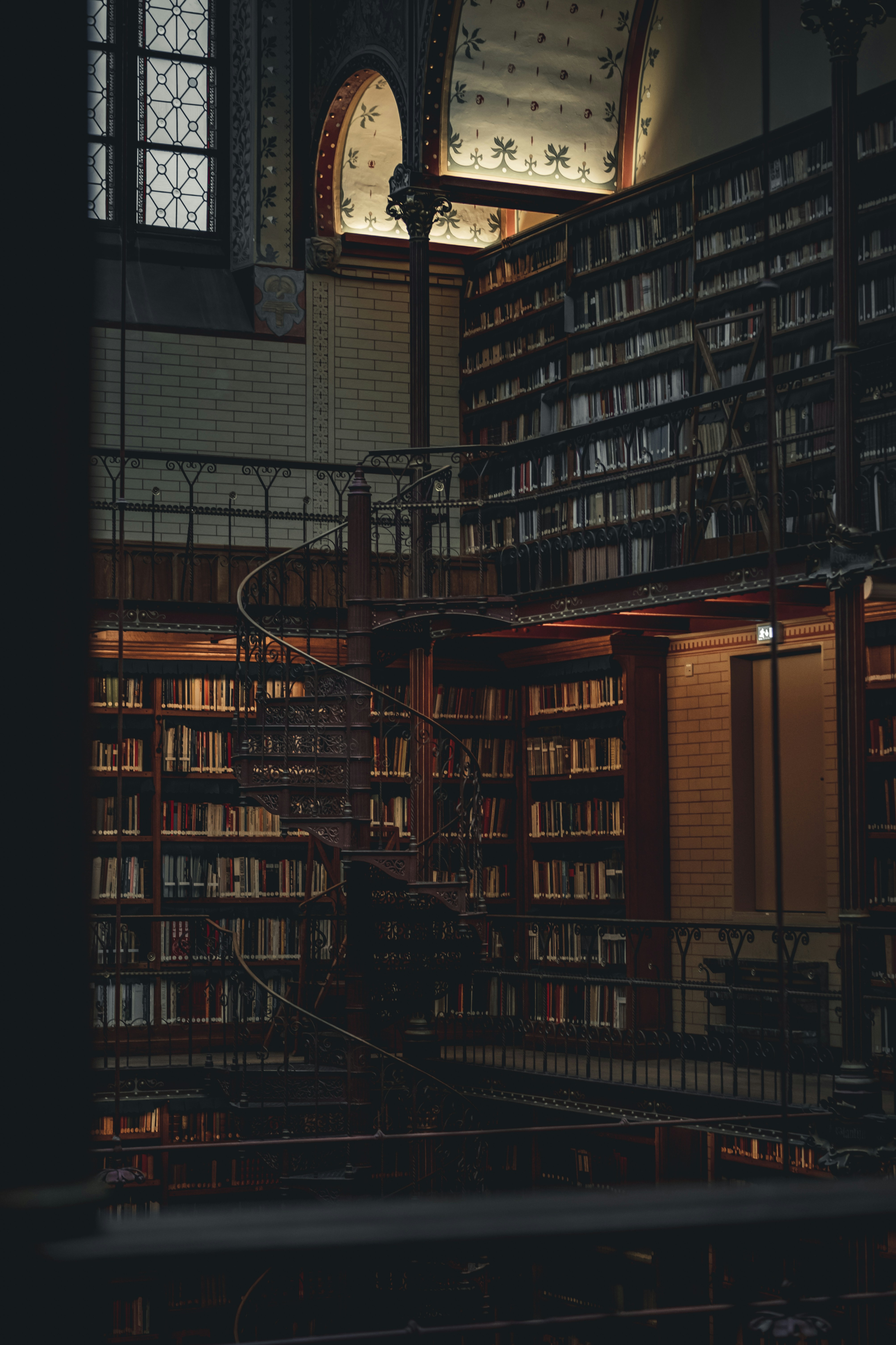 a large library with a spiral staircase and lots of books