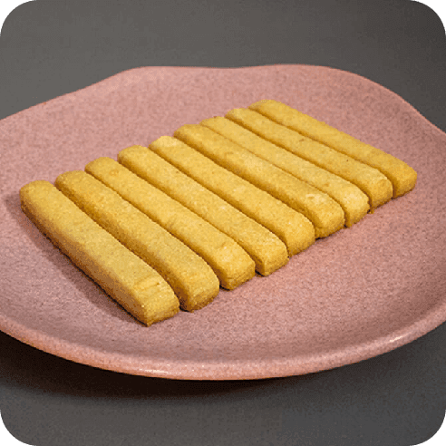 Galletas de mantequilla en forma de palitos rectangulares, alineadas sobre un plato rosado de cerámica.