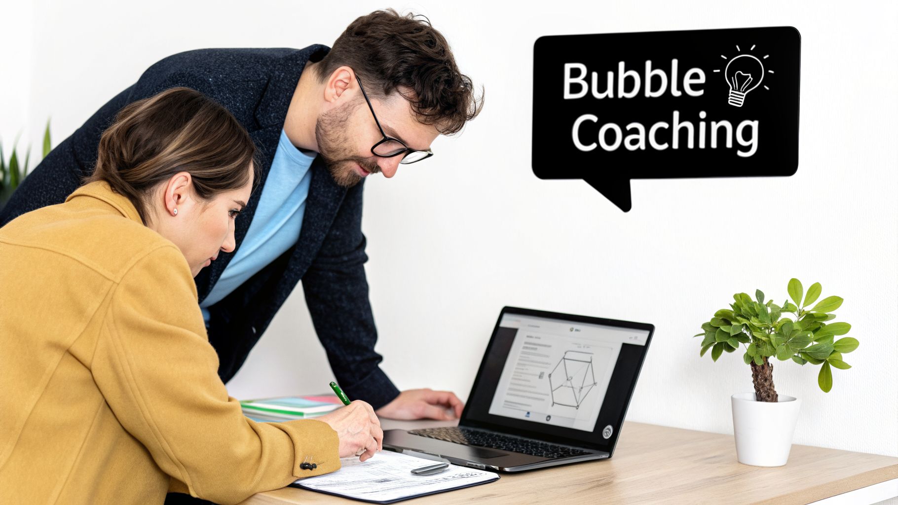 Two professionals collaborating on a laptop and documents during a coaching session.