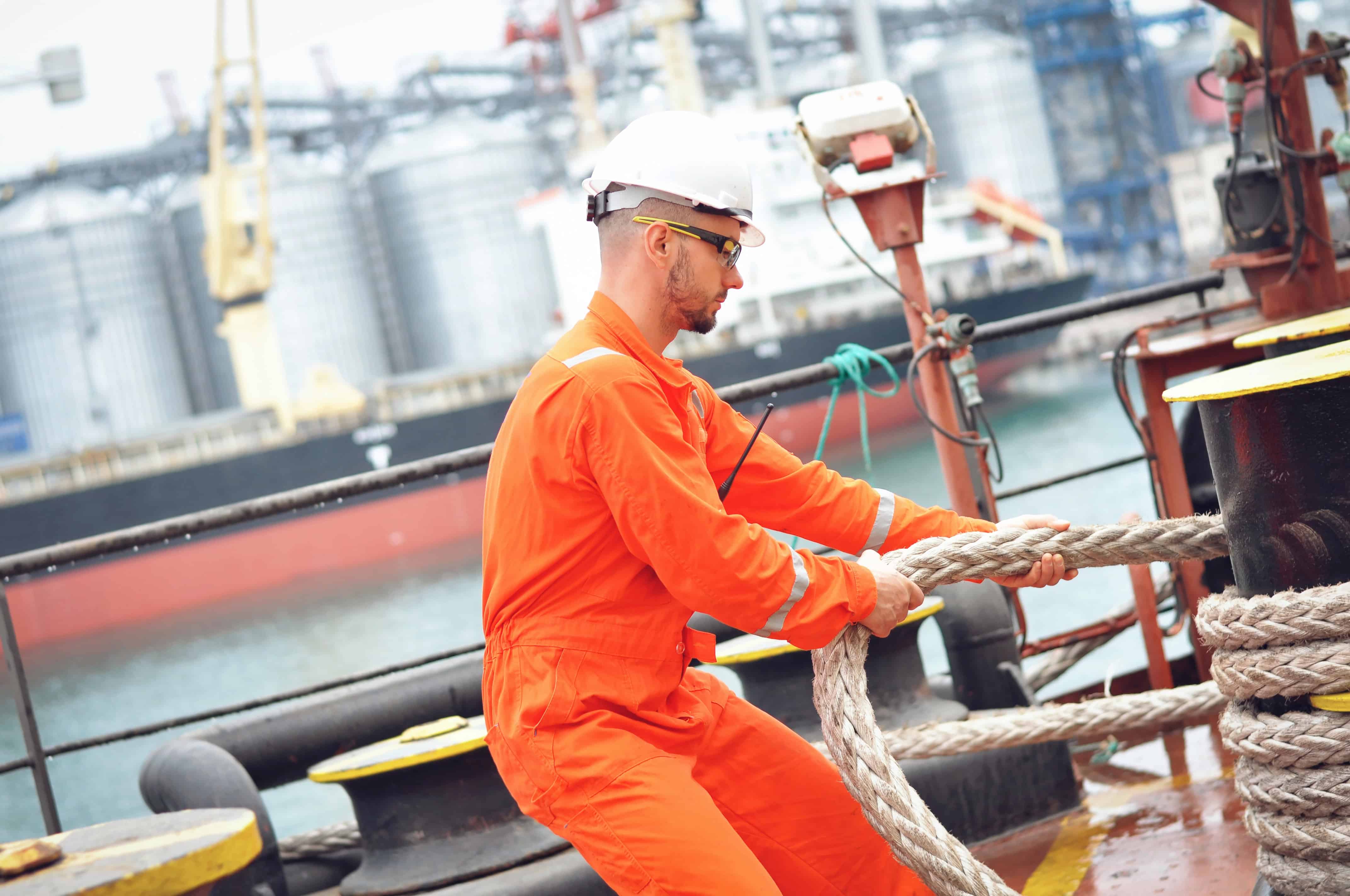Seafarer in coveralls going through safety training and following correct procedure for task execution