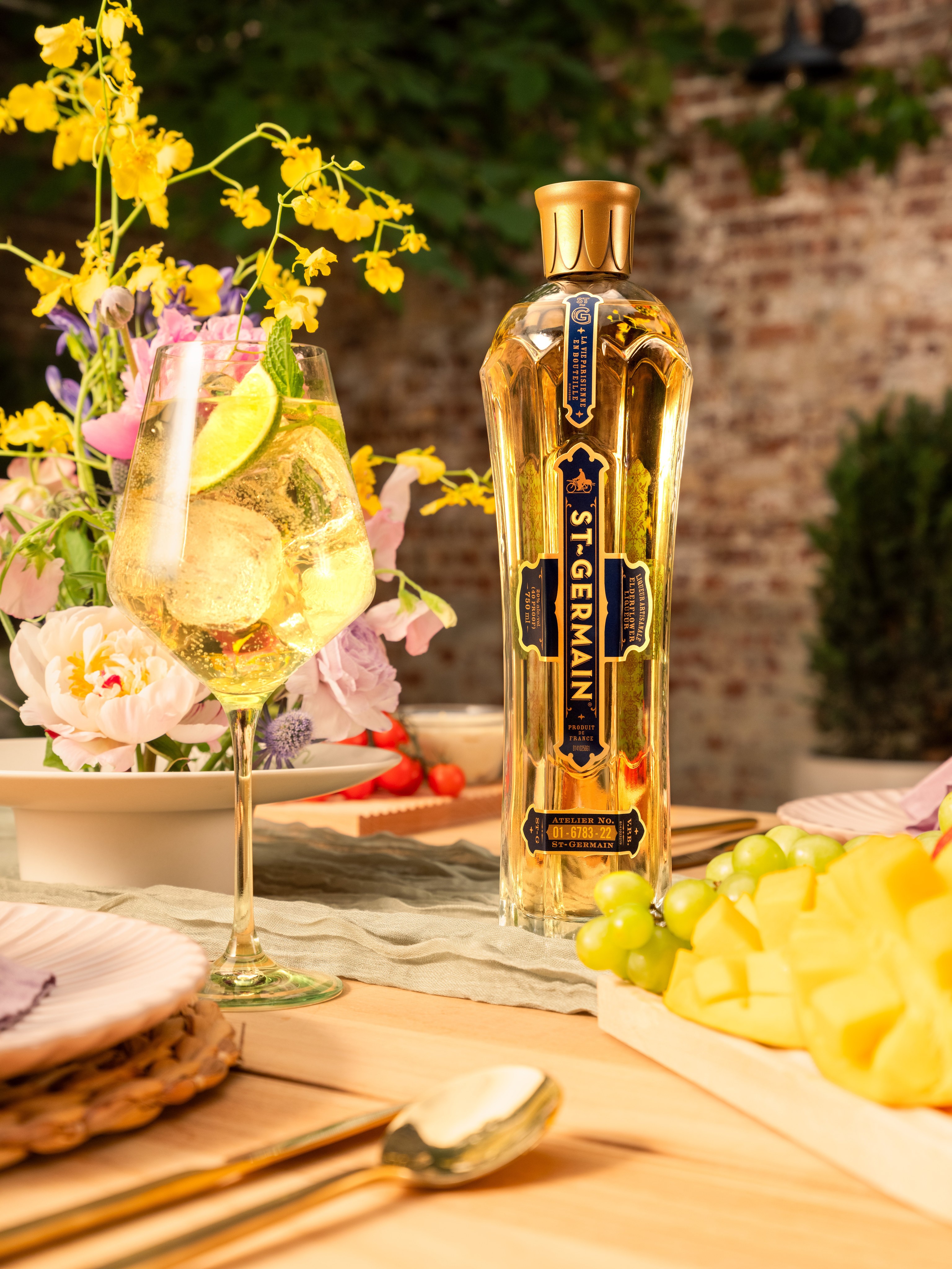 St Germain bottle framed by yellow flowers and a colorful garden table
