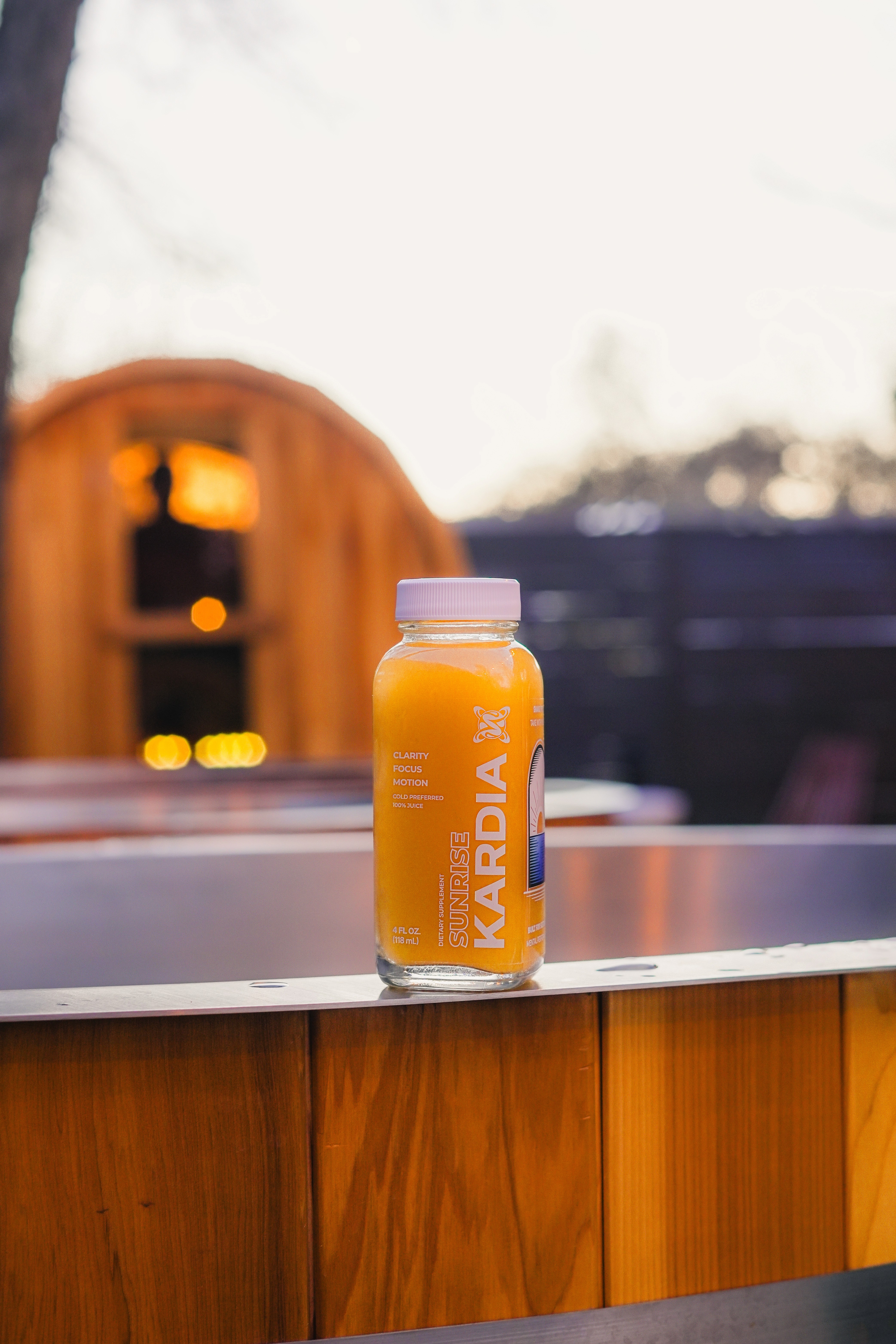 A woman in a striped shirt holds a credit card while using a laptop, bathed in warm sunlight in a cozy, modern setting.