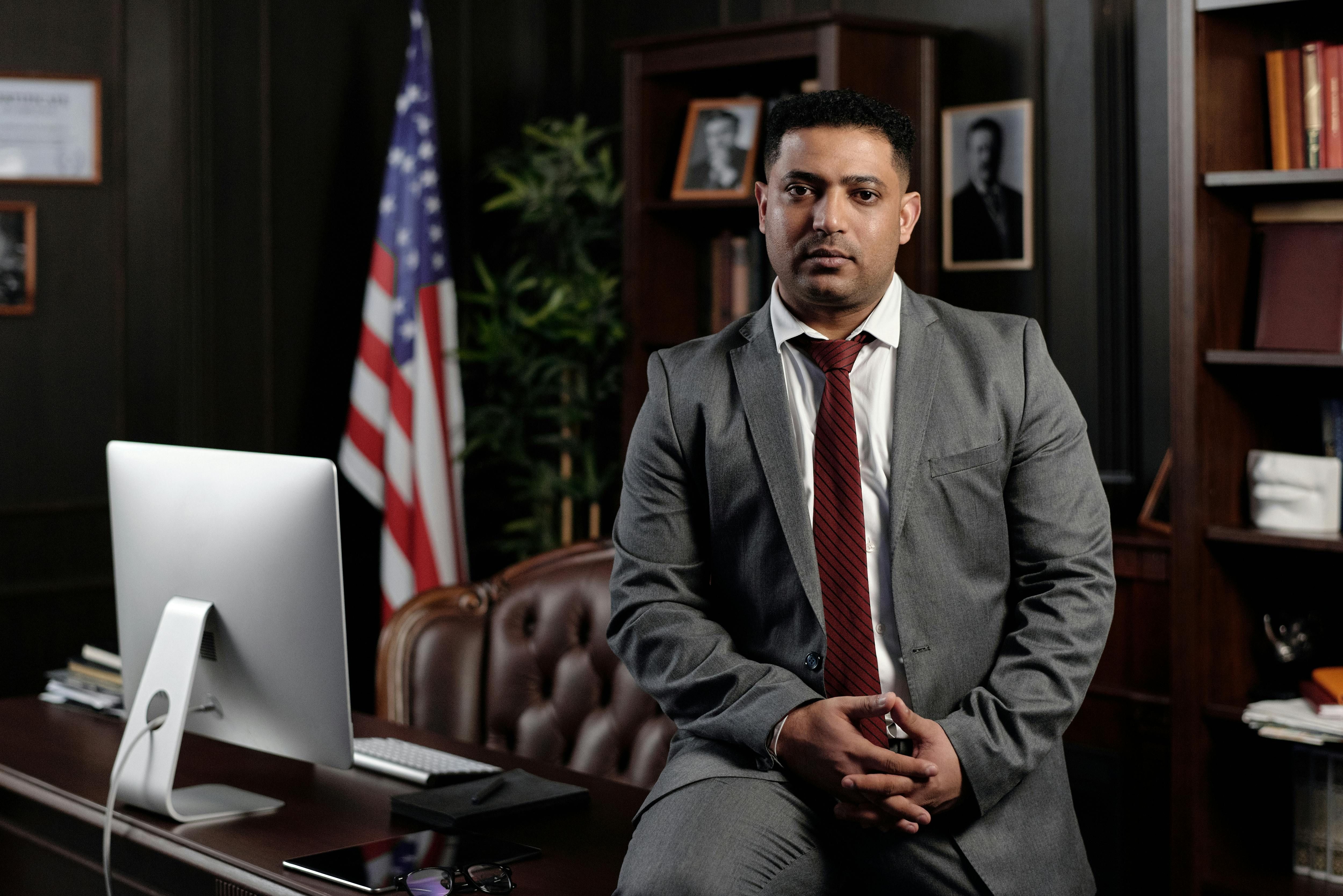 professional man sitting in an office with American flag.